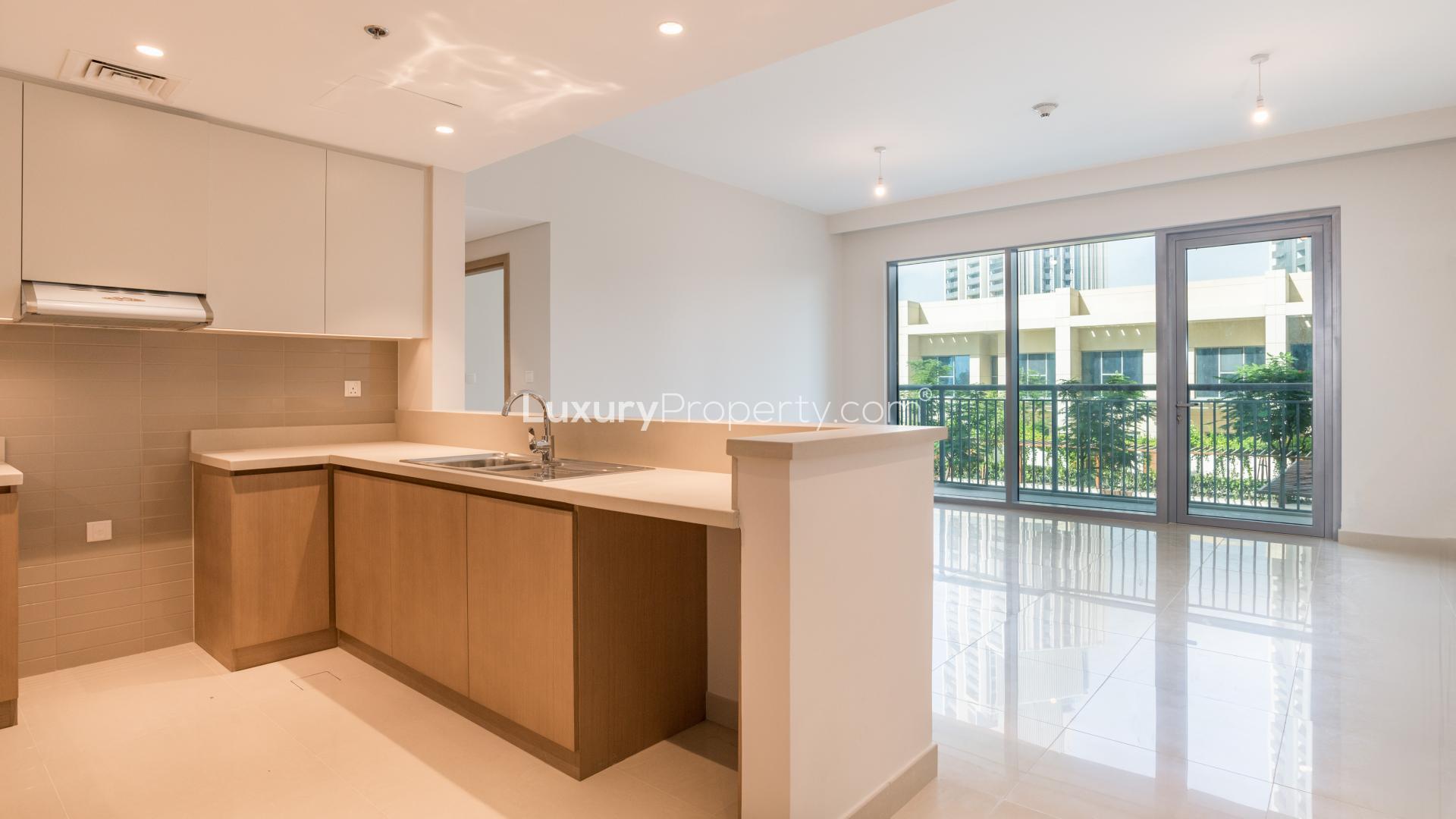 Spacious living room with large windows overlooking greenery in Dubai Creek Harbour apartment