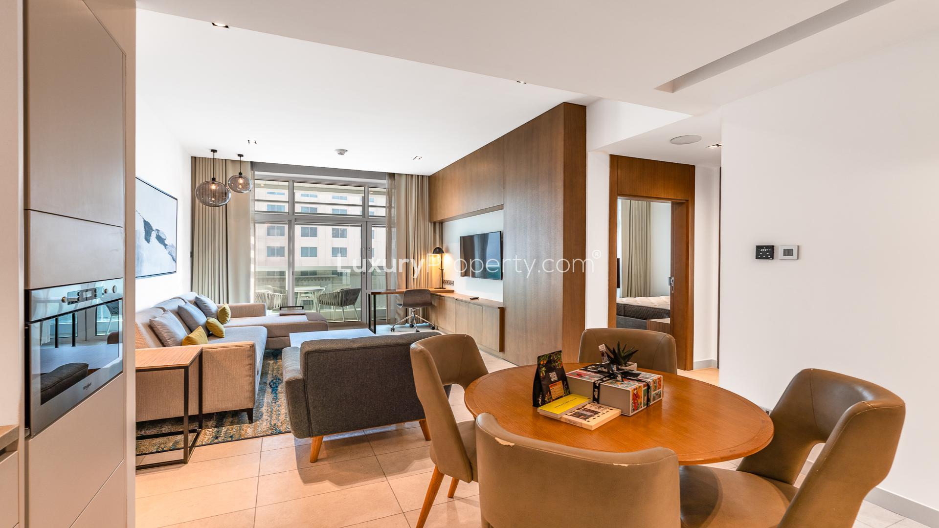 Modern living room in Marriott Al Jaddaf 2BR apartment, featuring stylish furniture and TV