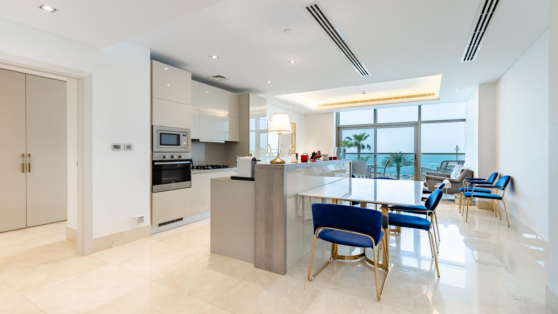 Modern living room in Palm Jumeirah apartment with sea view, vibrant decor, and balcony access