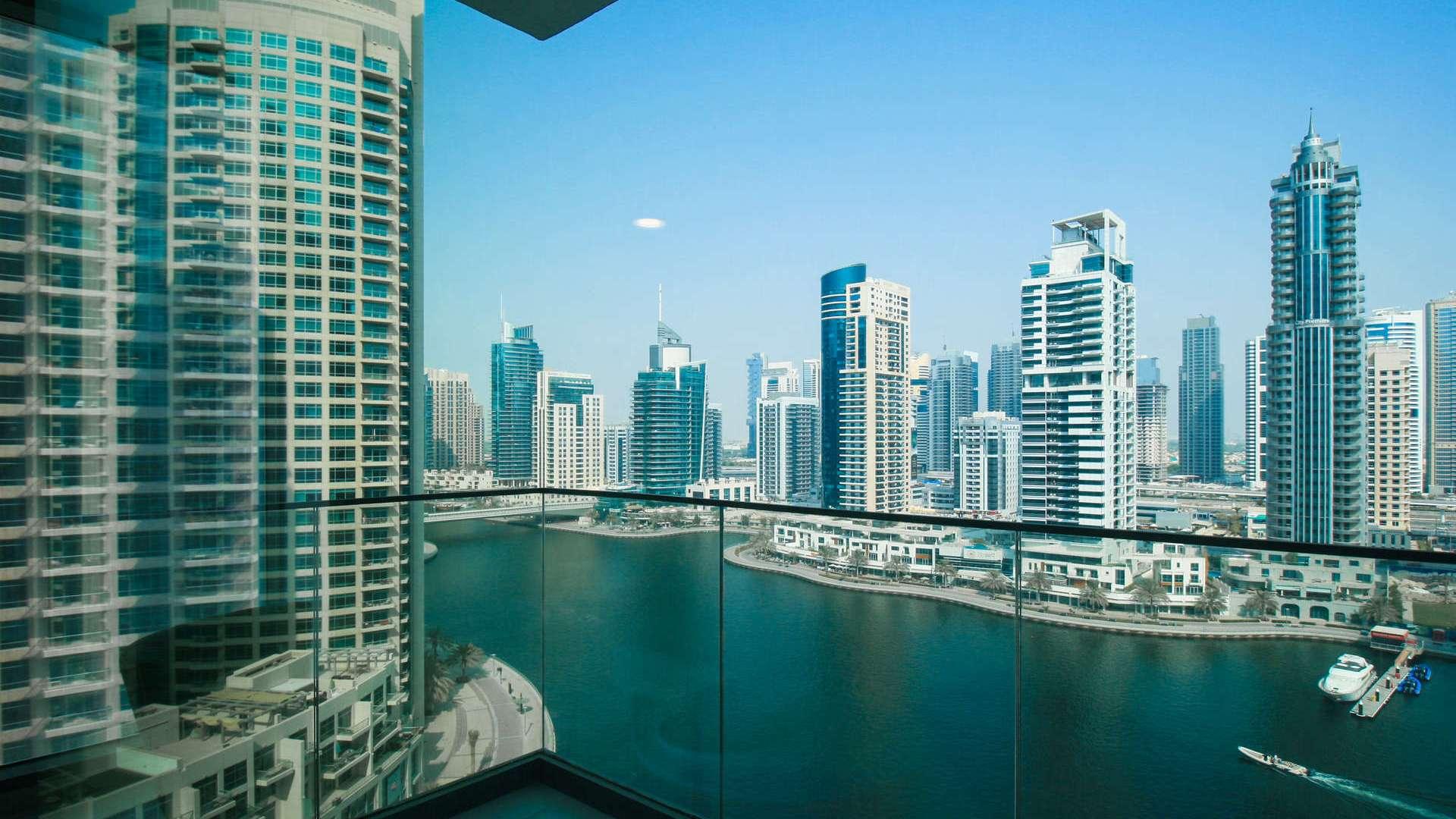 Modern living room in Dubai Marina apartment, featuring sleek furniture and large window view