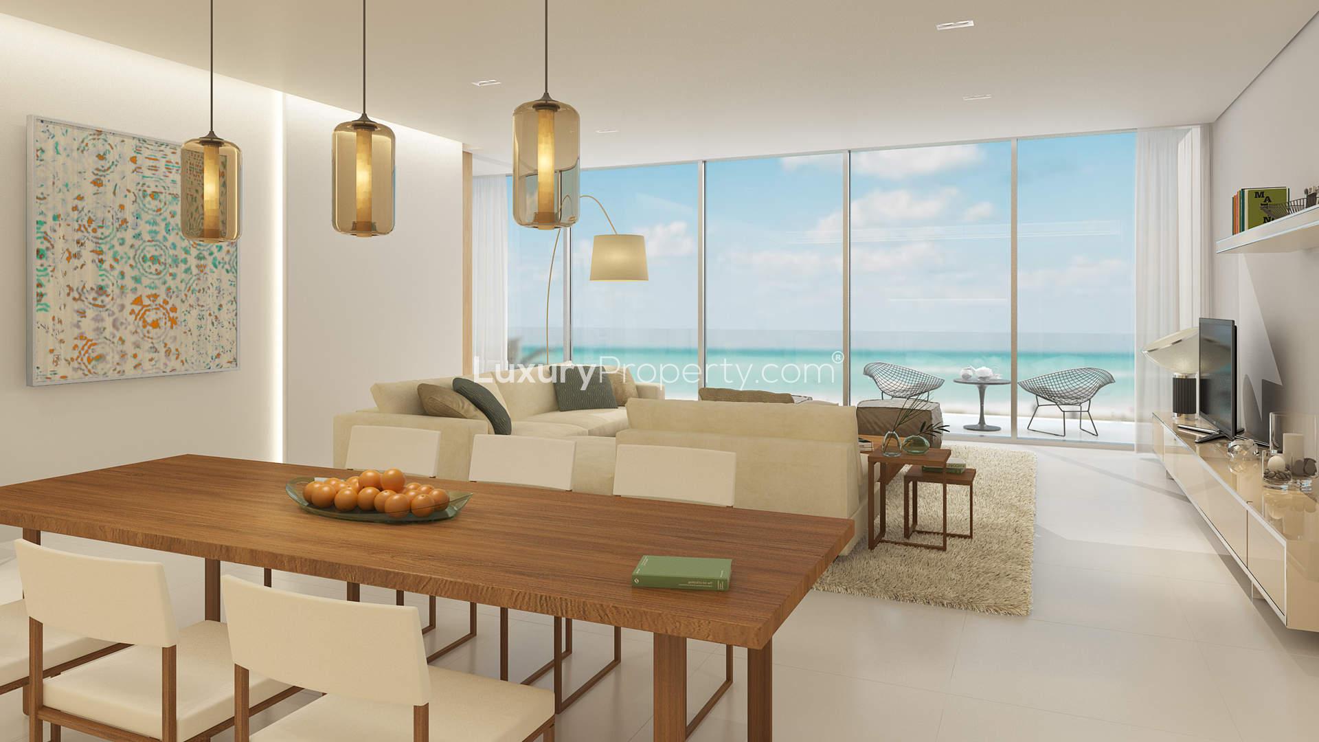 Aerial view of Mamsha Al Saadiyat beachfront apartments at sunset, Abu Dhabi skyline visible