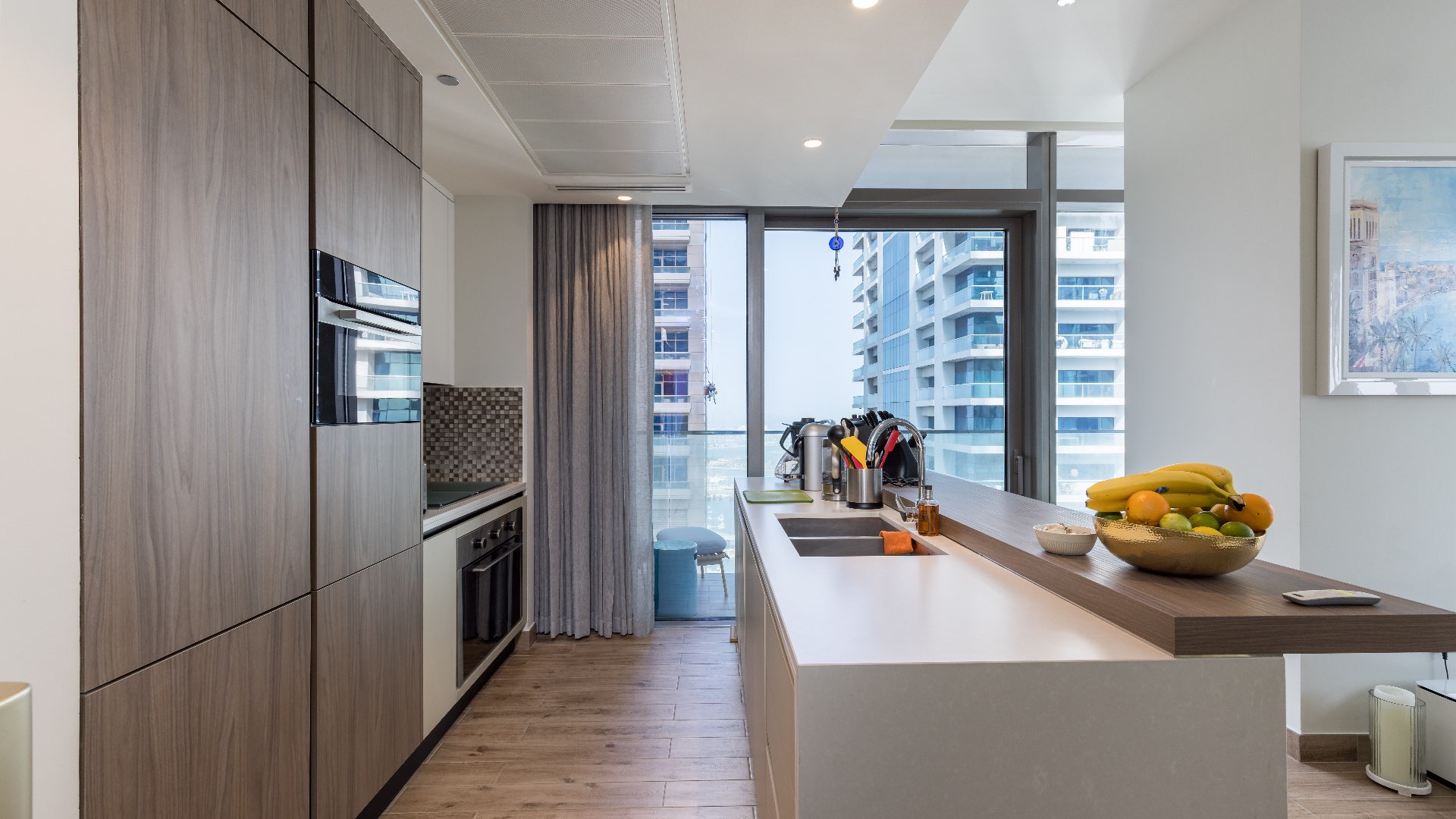 Modern kitchen in upgraded Jumeirah Living Marina Gate apartment, Dubai Marina, with balcony view