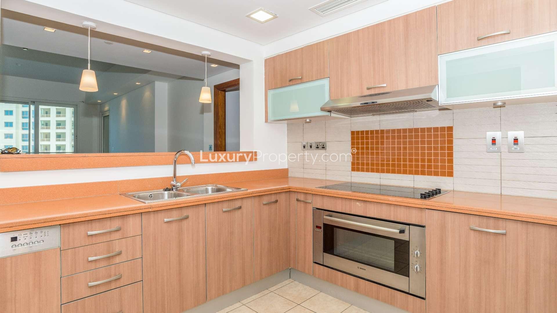 Spacious living room in Marina Residences apartment, Palm Jumeirah, with large windows and tile flooring