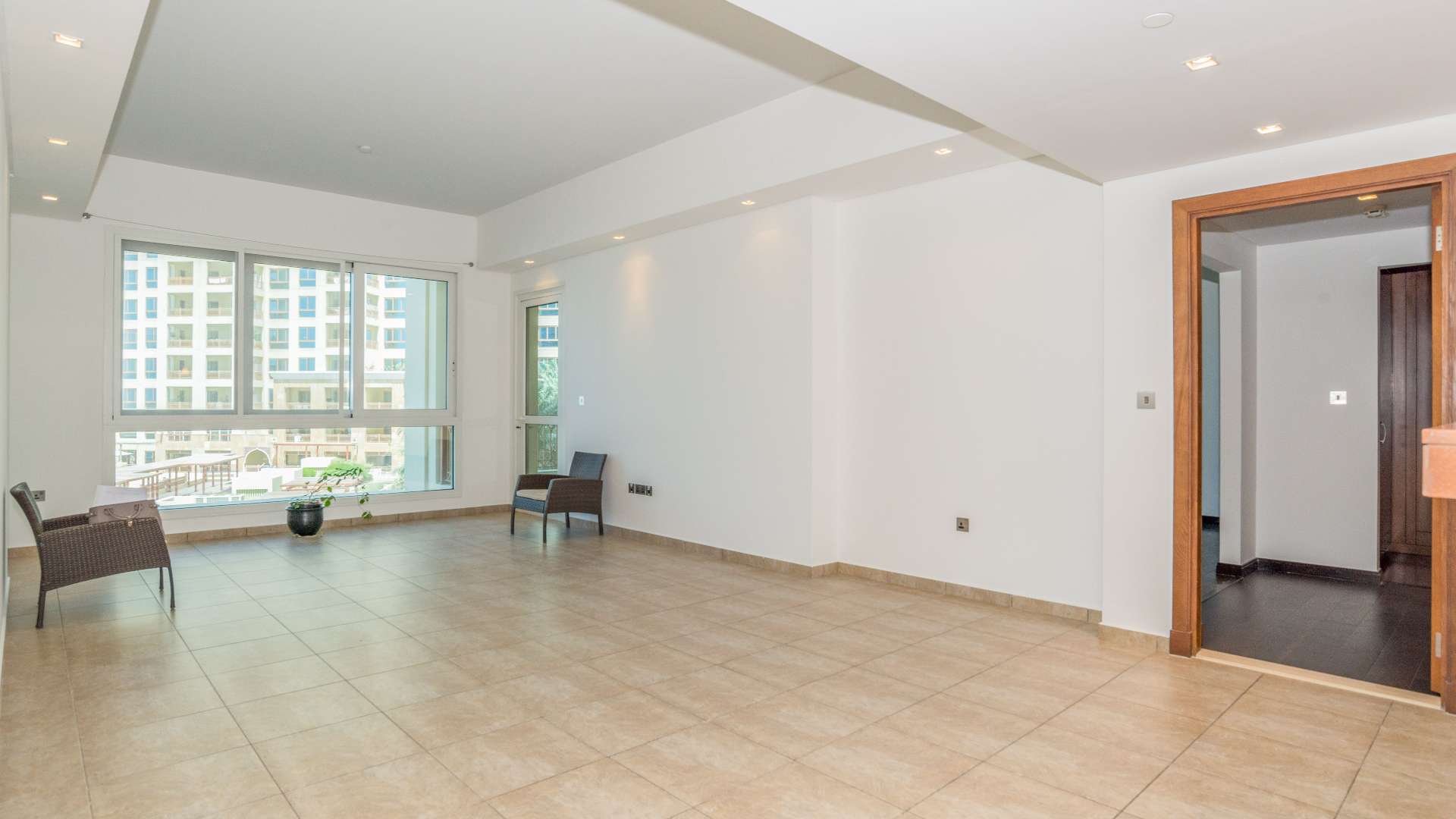 "Spacious living room in sea-facing Palm Jumeirah apartment, direct Nakheel Mall access, for sale.",Vacant living room in sea-facing apartment, Palm Jumeirah, near Nakheel Mall