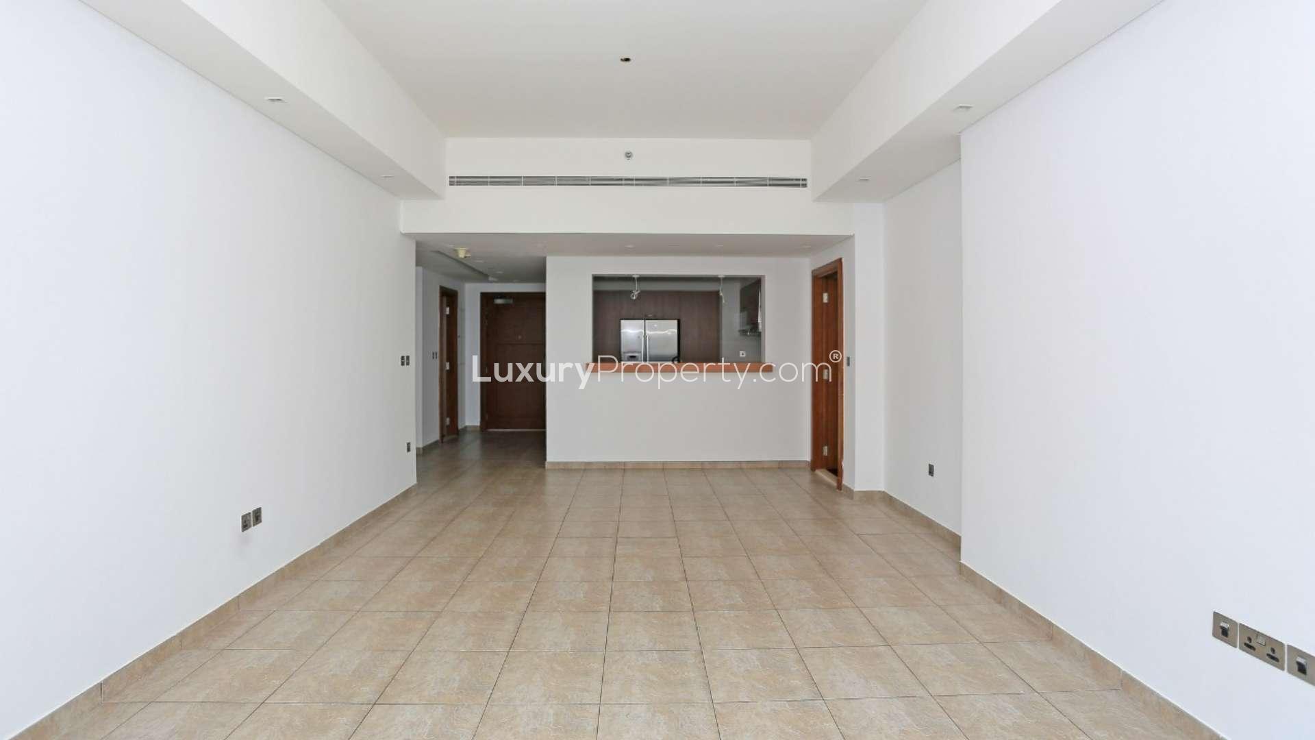 Empty living area in Marina Residence apartment, large windows, tiled floor, Palm Jumeirah