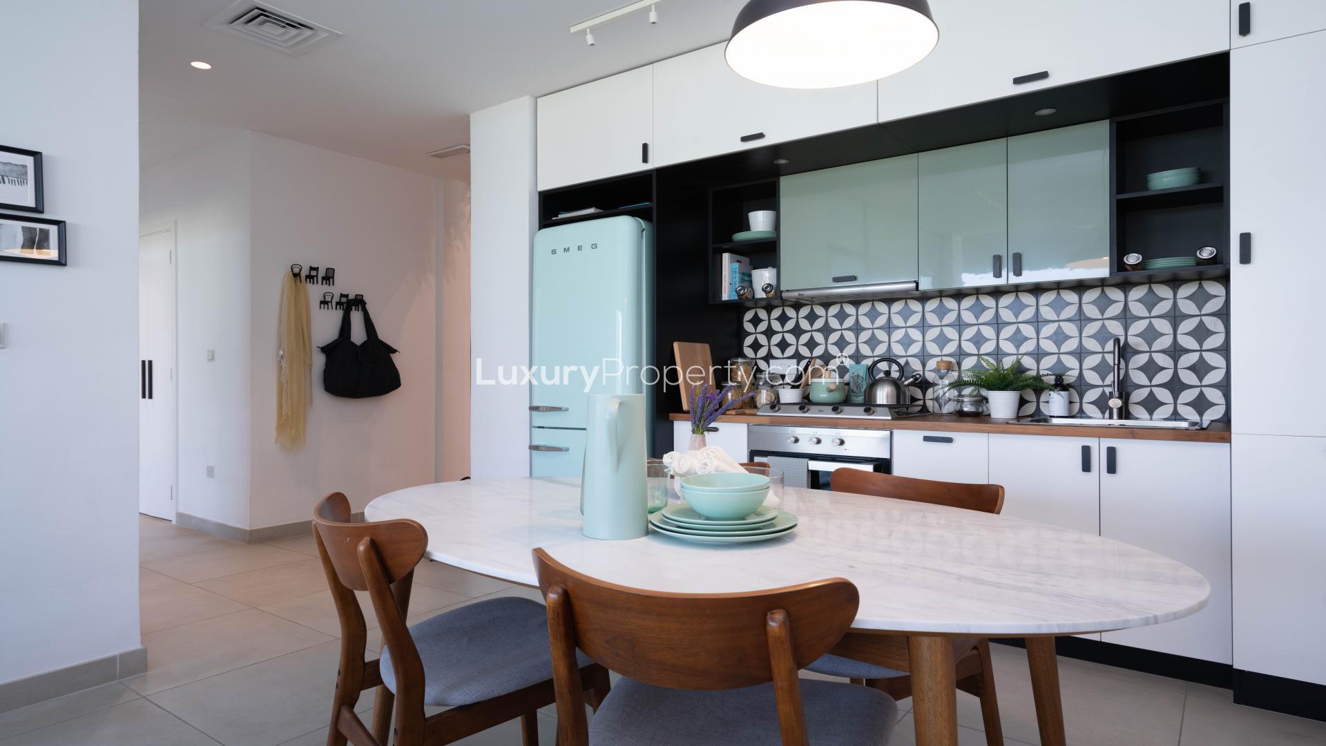 Modern kitchen in Dubai Hills Estate apartment, featuring stylish cabinetry and elegant dining area