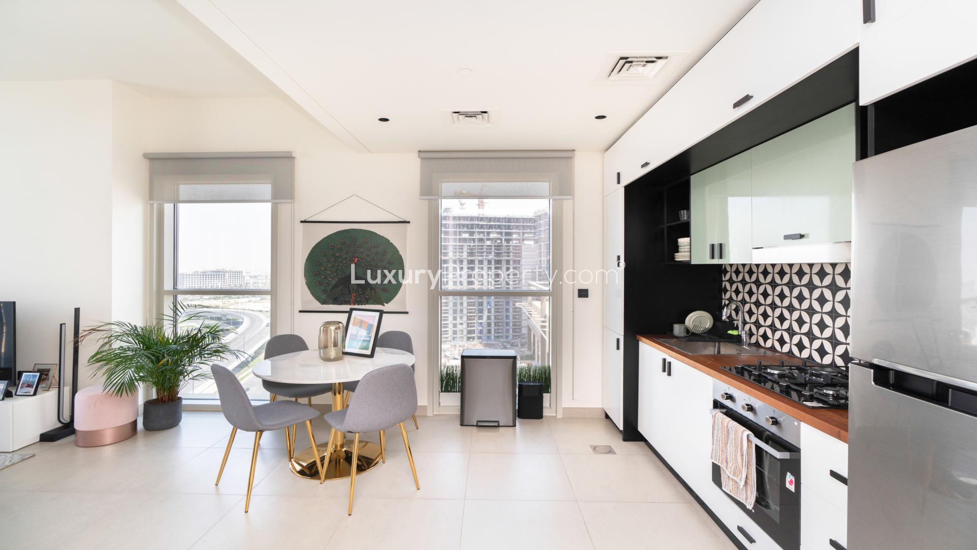 Modern kitchen and dining area in Dubai Hills Estate apartment, with city view
