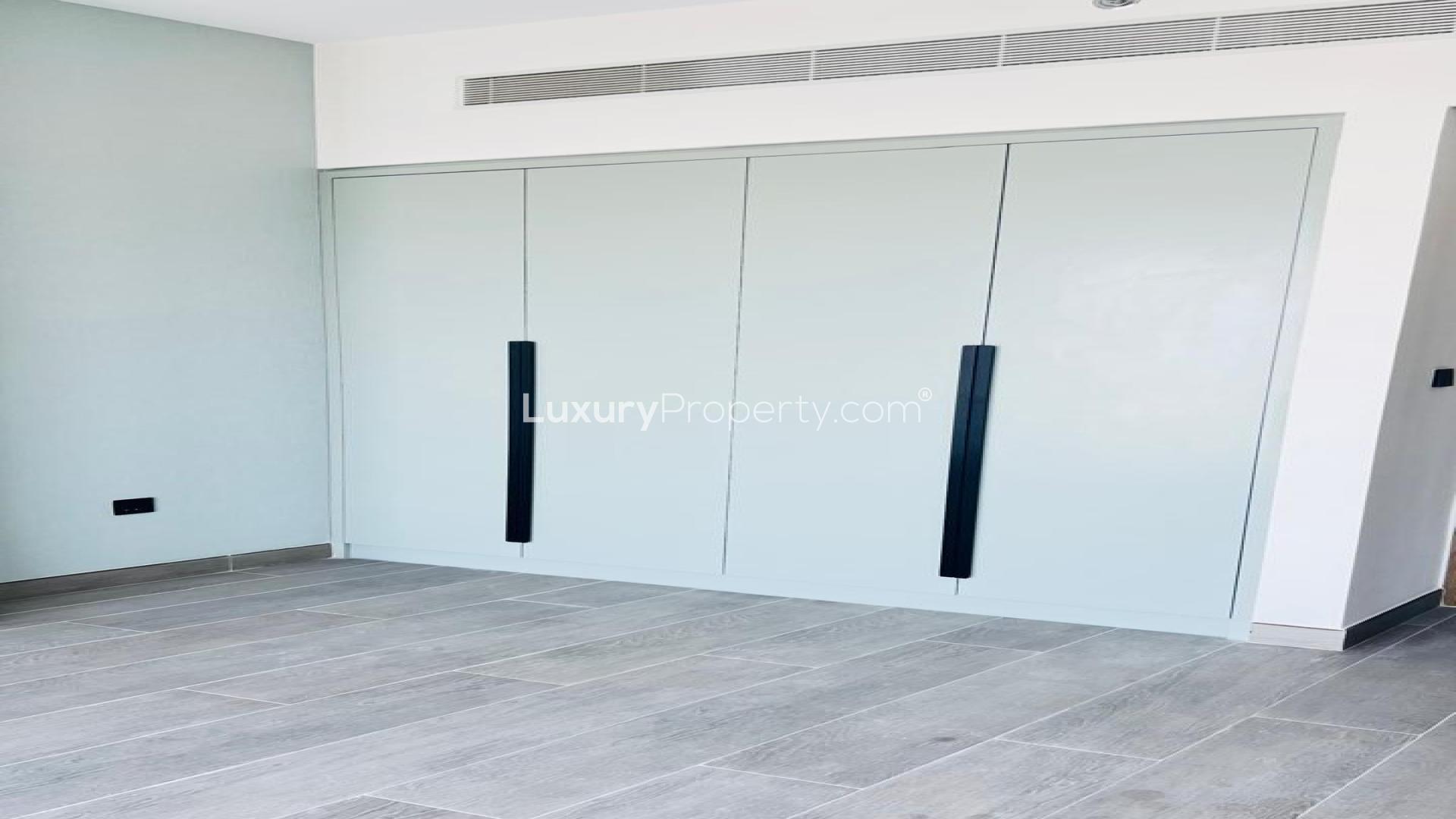 Modern bedroom with built-in wardrobe in Golf Gate apartment, Damac Hills. For sale