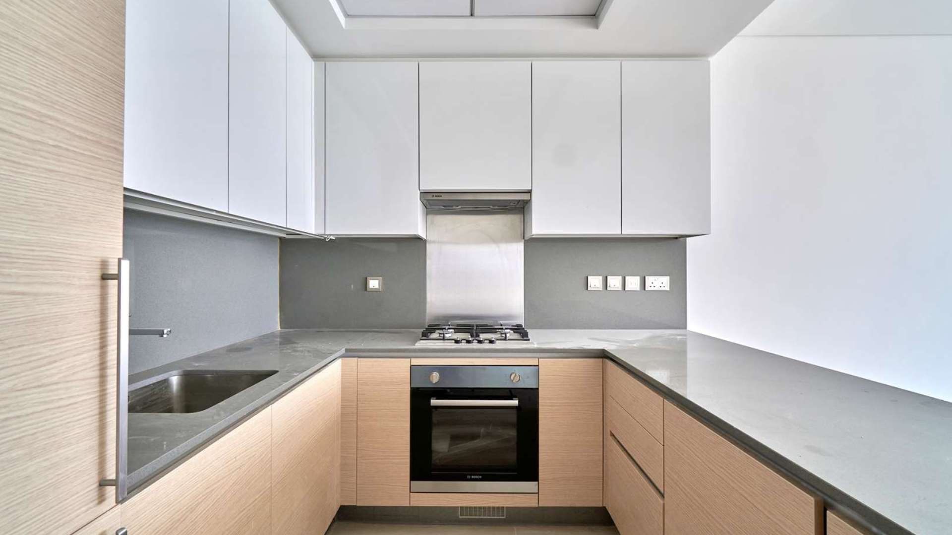 "Modern Azizi Mina building exterior in Palm Jumeirah, Dubai, showcasing luxury residential apartments.",Modern kitchen in 2-bedroom Palm Jumeirah apartment for sale, featuring sleek countertops and cabinetry