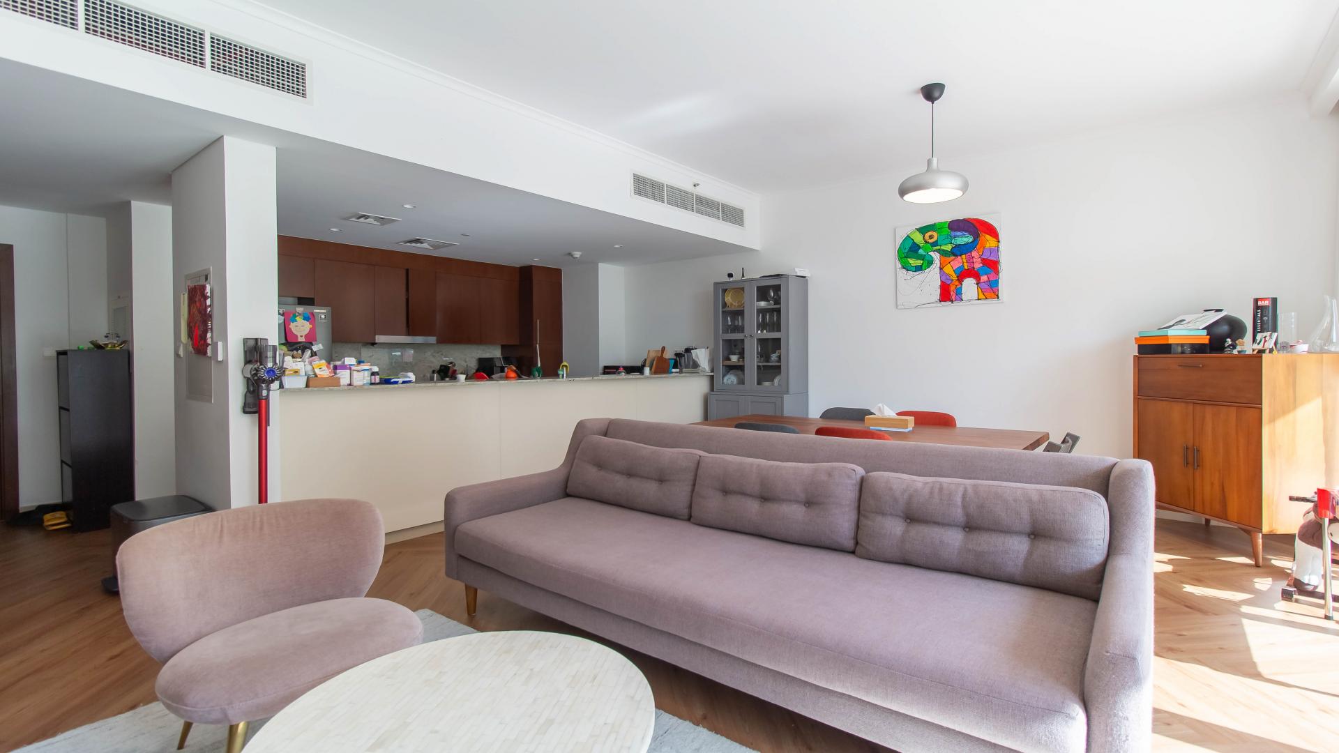 Living room in pool-facing apartment, Mulberry, Dubai Hills Estate, with modern decor and patio view