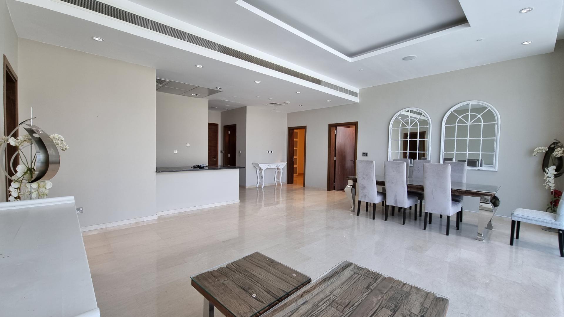 Alt text: "View from premium apartment in Oceana, Palm Jumeirah, showcasing modern architecture and greenery.",Spacious living and dining area in premium Oceana apartment, Palm Jumeirah. Elegant interior design