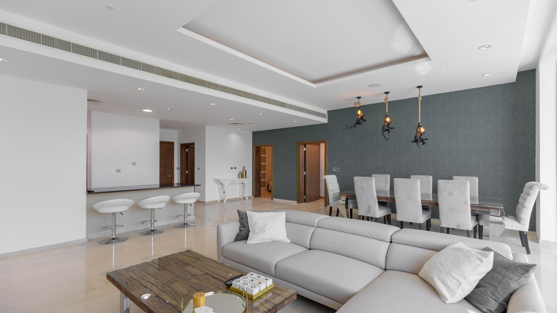 Modern open-plan living room and kitchen with sea view in Palm Jumeirah apartment