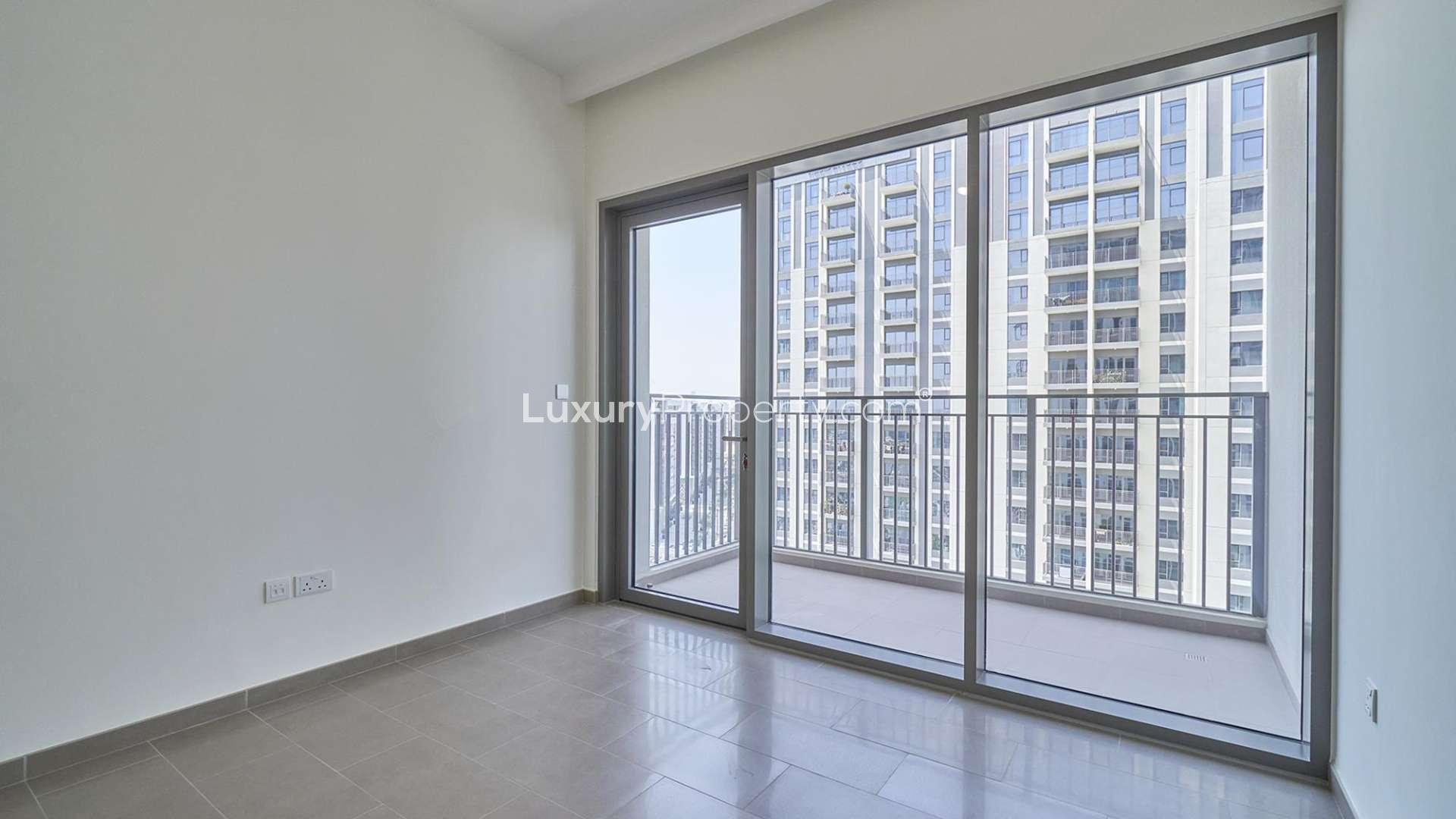 "Modern high-rise apartment building exterior in Park Heights, Dubai Hills Estate for sale.",Empty room with large windows and balcony view in Park Heights 2, Dubai Hills Estate