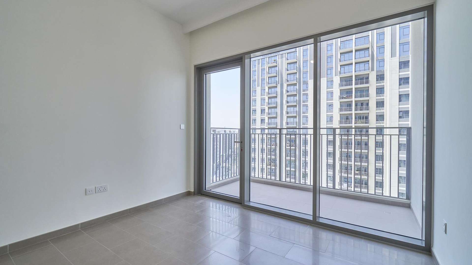 "Skyline view of Park Heights II, Dubai Hills Estate apartments available for sale.",Empty room with large windows and balcony view in Park Heights II, Dubai apartment