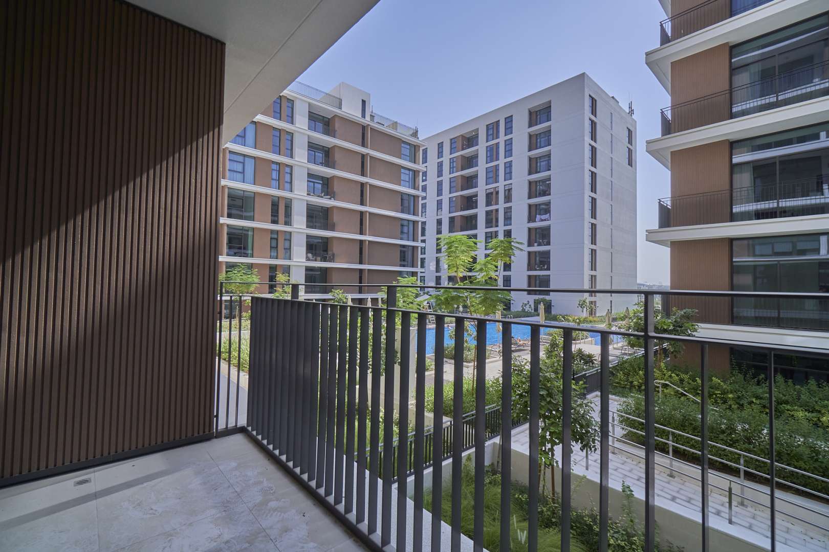 Empty bedroom with large window overlooking pool in Dubai Hills Estate apartment
