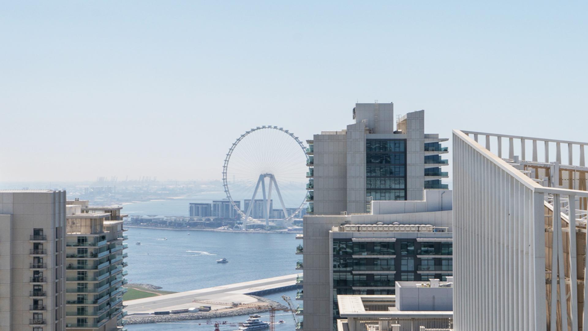 Luxury Dubai Harbour apartment view with waterfront and iconic Ferris wheel in Emaar Beachfront