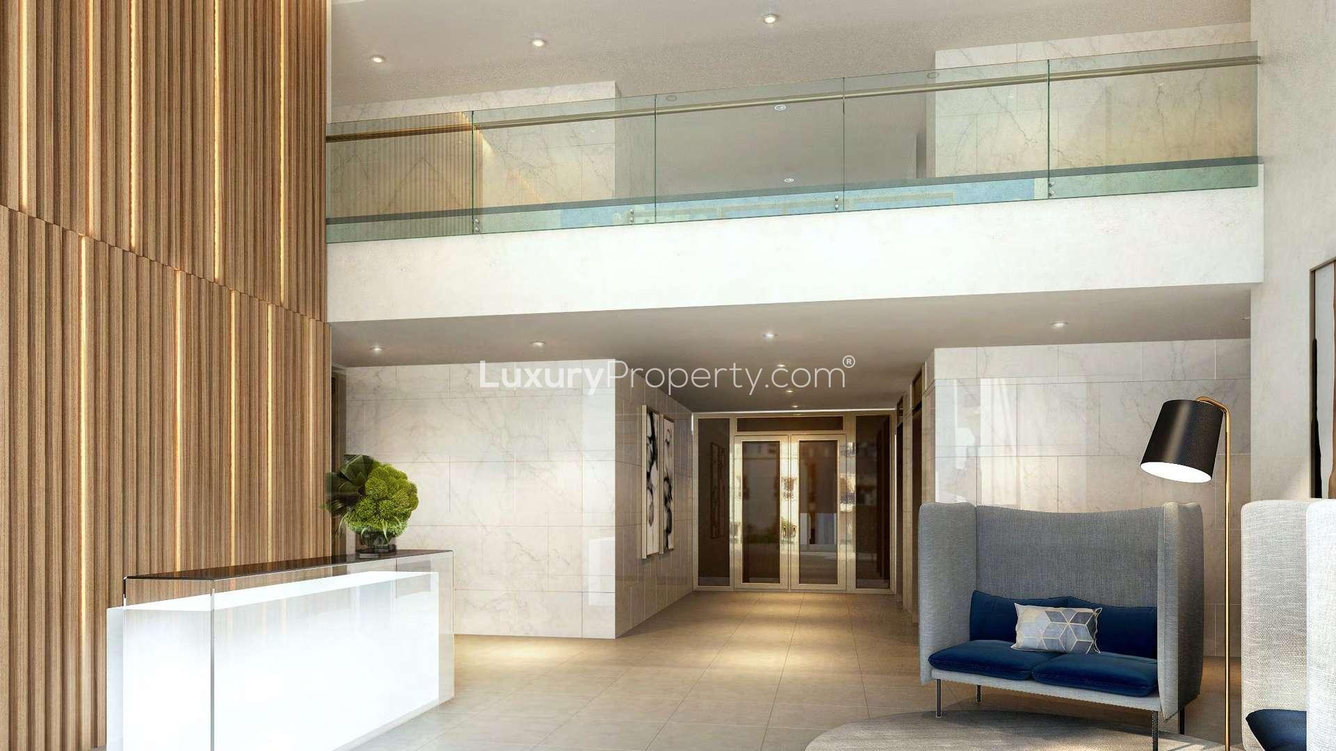 "Modern apartment building exterior in Remraam, Dubailand, for sale, two bedrooms, balconies.",Contemporary lobby in two-bedroom apartment, Remraam, Dubailand, featuring modern design and seating