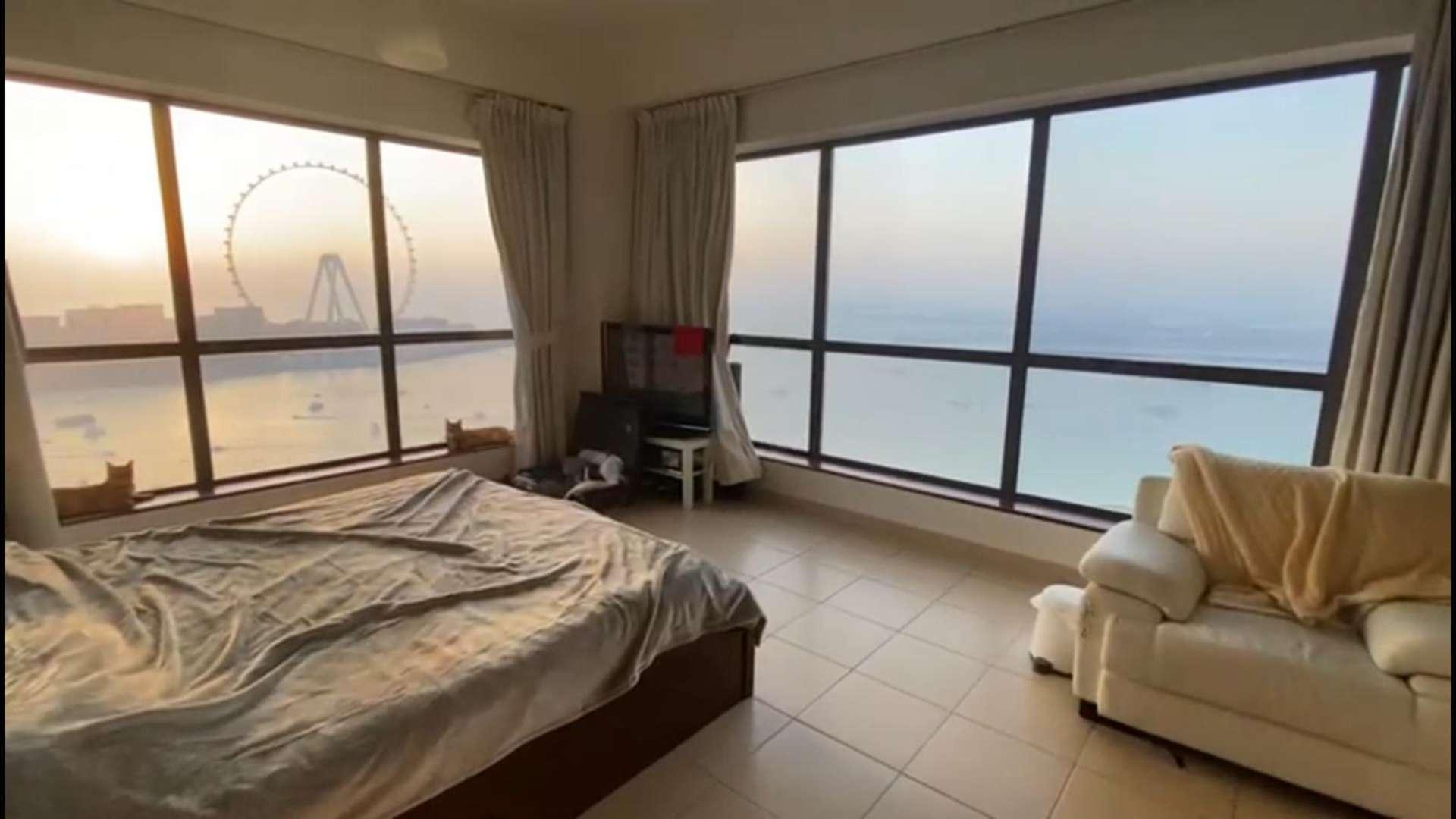 Empty living room with sea view through large window in JBR Rimal apartment