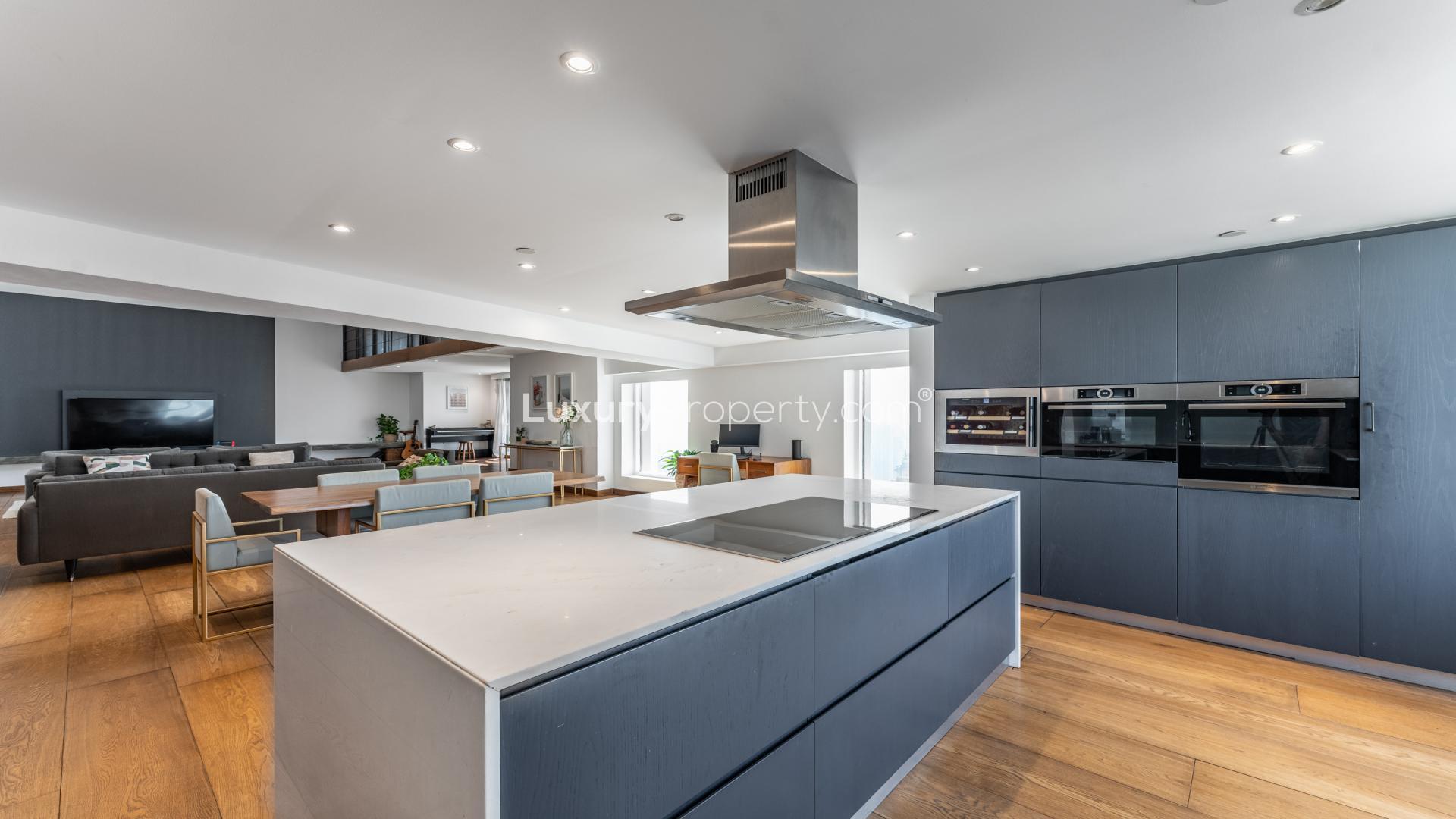 Modern open-plan living room in Sadaf apartment, Jumeirah Beach Residence, with mezzanine and staircase