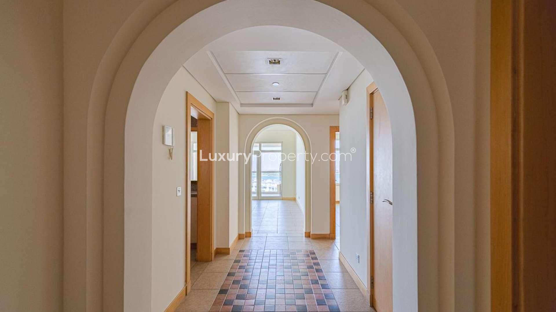 Empty room in Shoreline Apartments, Palm Jumeirah, featuring wooden doors and tiled flooring