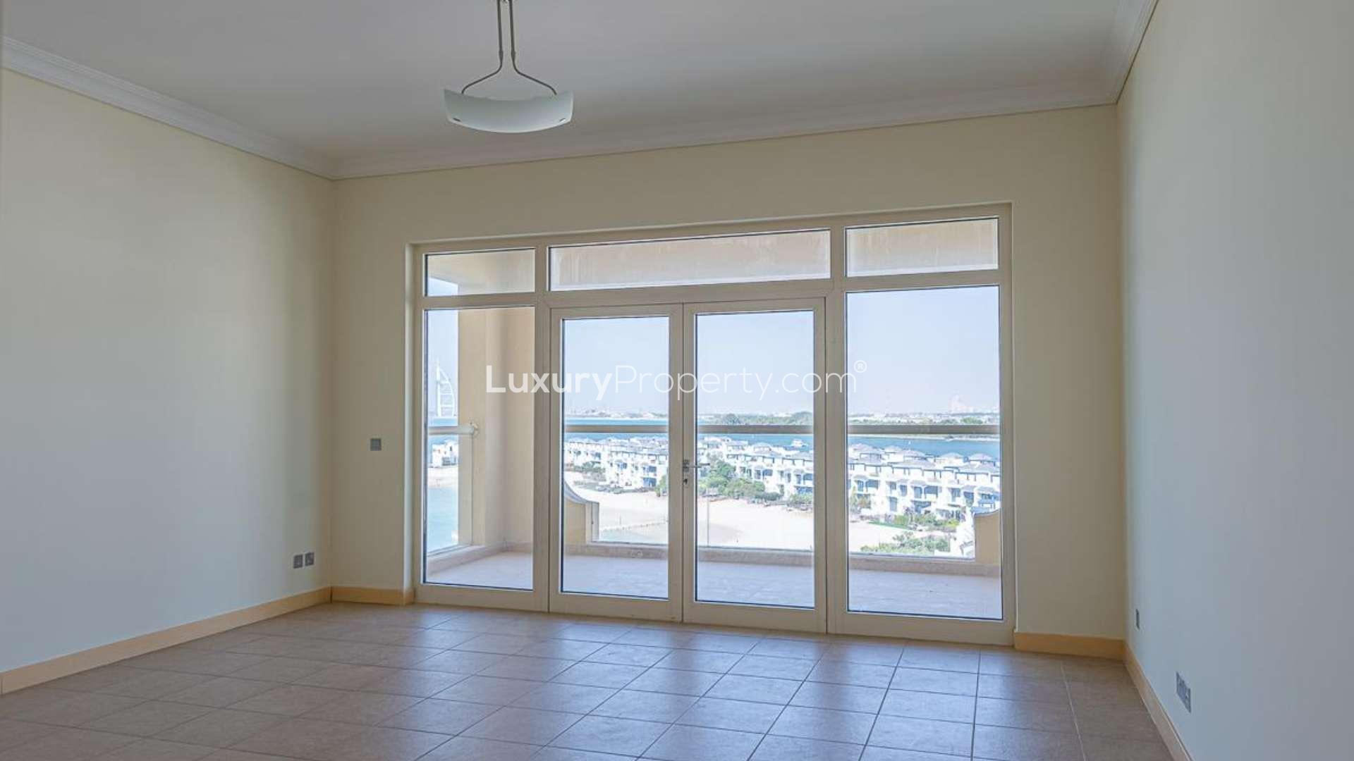 "Spacious living room with balcony view in Shoreline Residences, Palm Jumeirah apartment for sale.",Empty living room in 2-bedroom apartment, Shoreline Residences, Palm Jumeirah, with open kitchen view