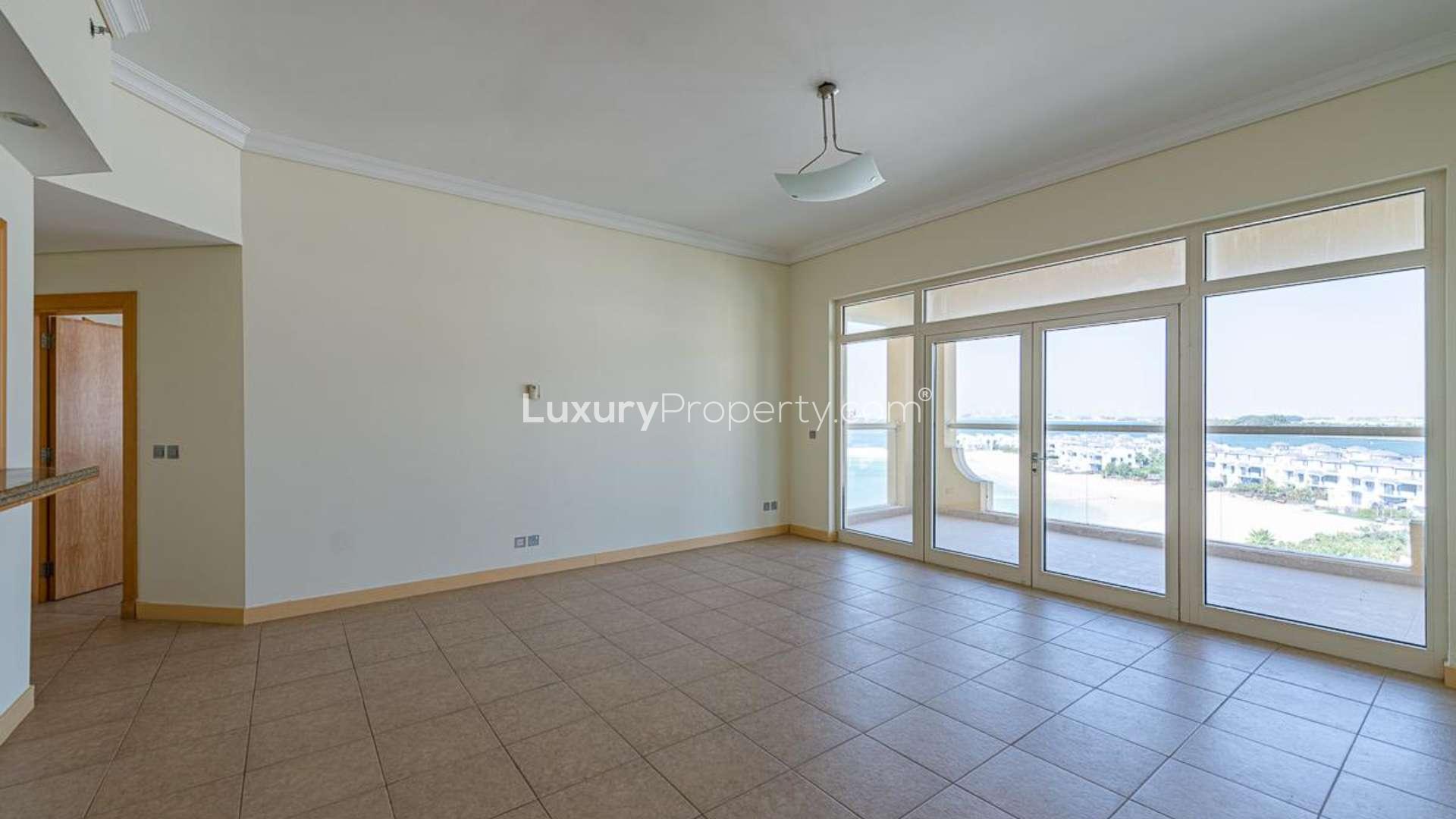 "Spacious hallway in 2-bedroom Shoreline Apartment, Palm Jumeirah, featuring elegant archways and tiles.",Empty living room with large windows and sea view in Shoreline Residences, Palm Jumeirah apartment