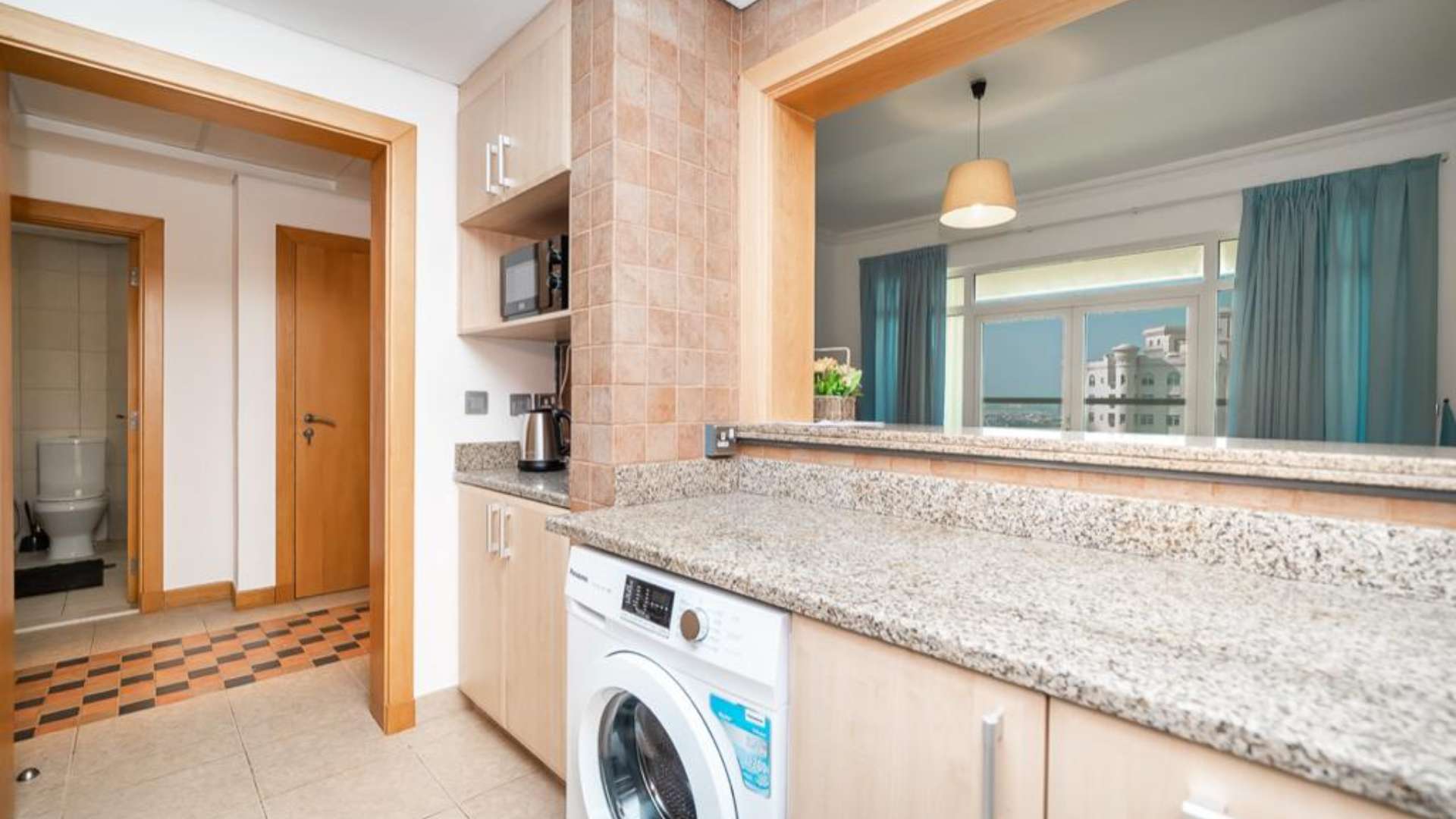 Bedroom interior in E-Type Shoreline Apartment, Palm Jumeirah, with wardrobe and window view