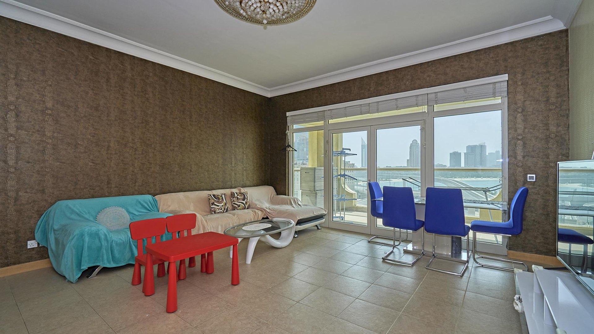 Exterior view of Shoreline Apartments in Palm Jumeirah, featuring tall palm trees