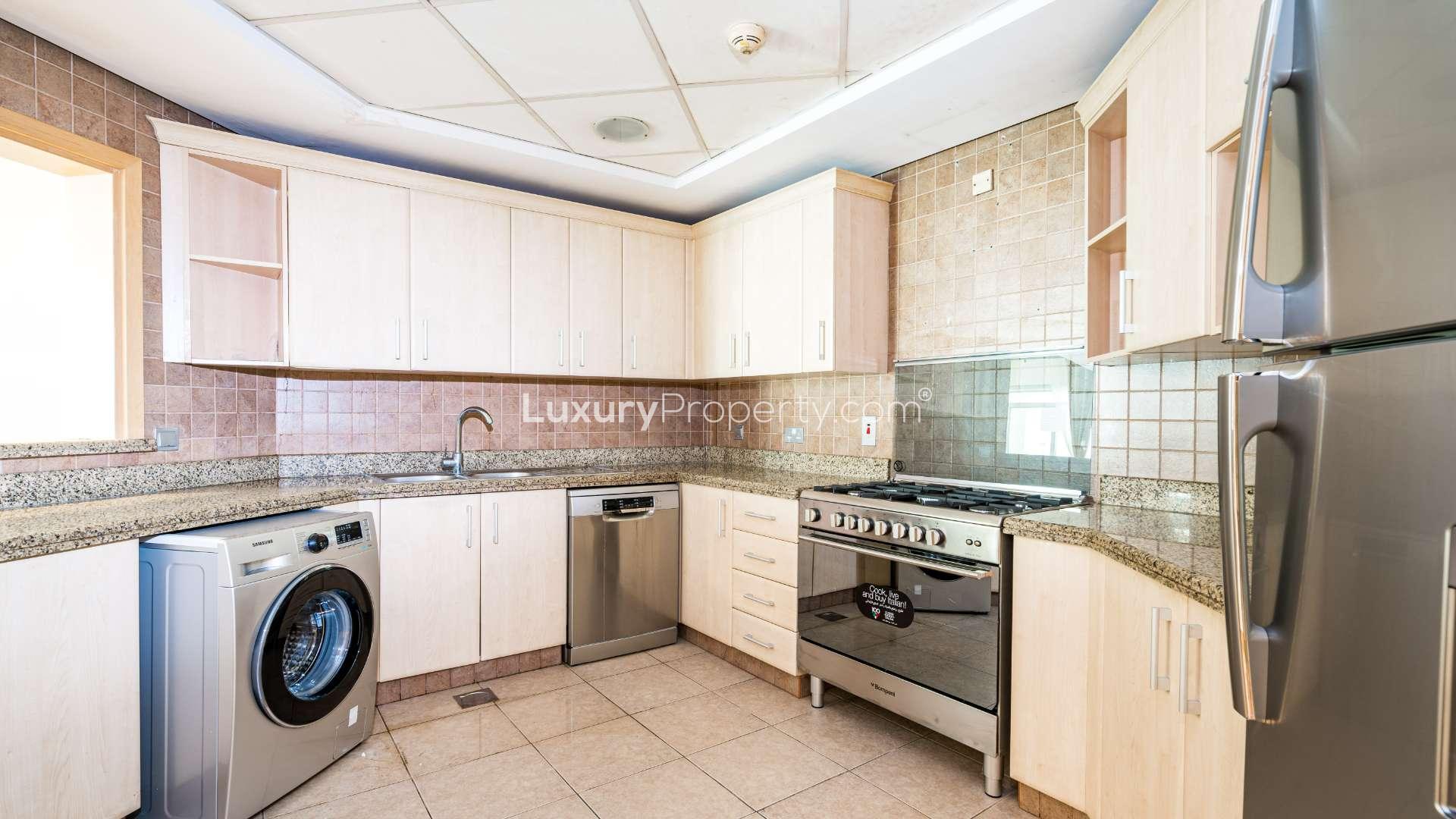 Modern kitchen in Palm Jumeirah apartment, featuring stainless steel appliances and granite countertops