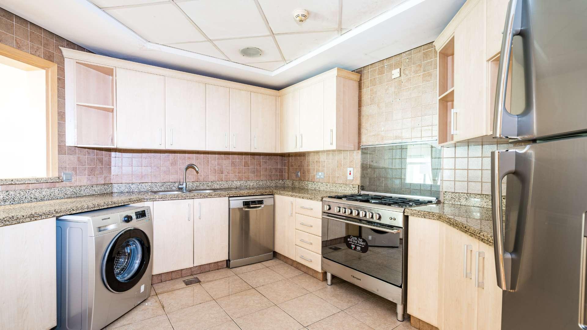 Modern kitchen in Palm Jumeirah apartment, featuring stainless steel appliances and granite countertops