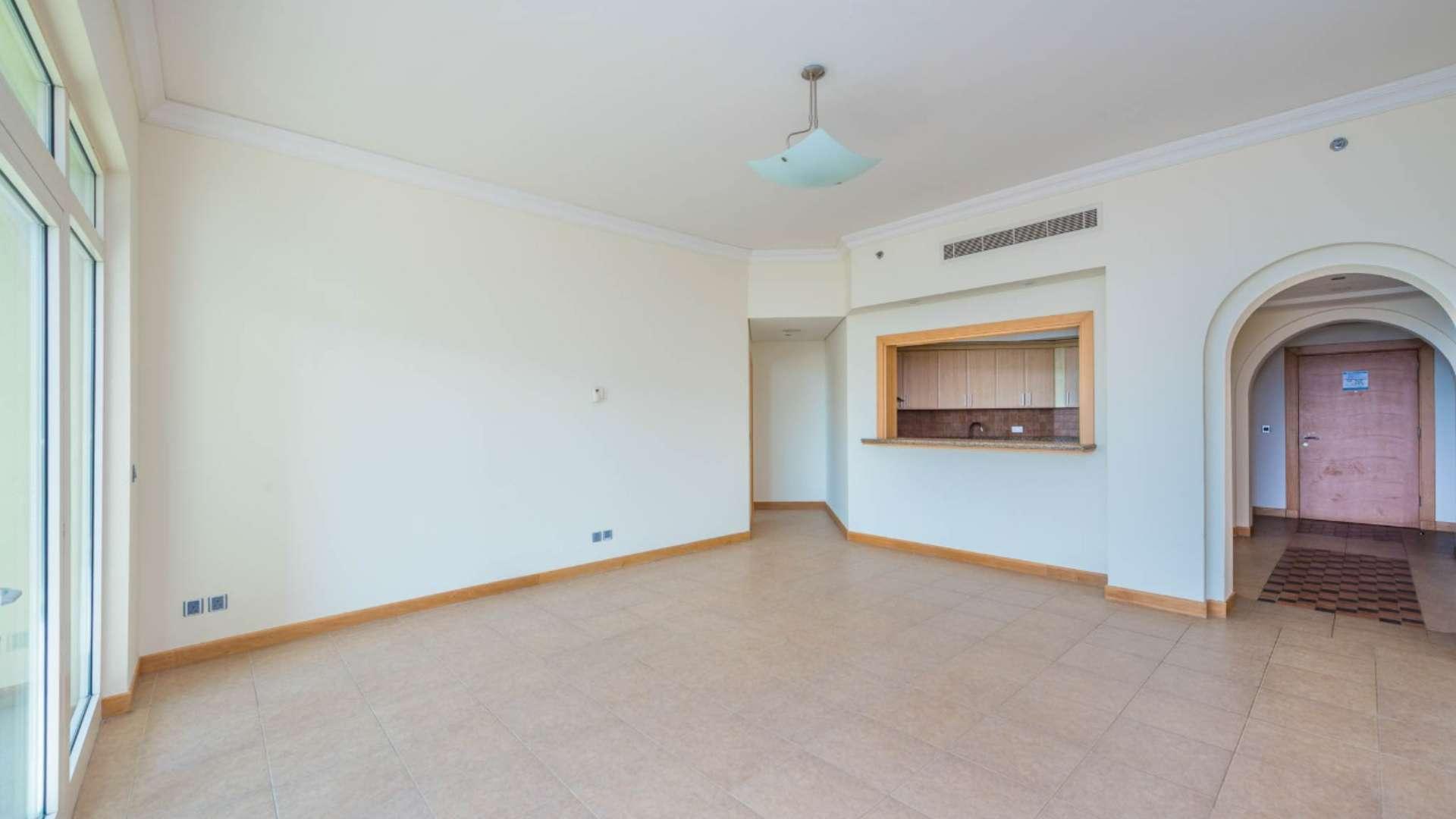 "Spacious beachfront apartment with sea view in Palm Jumeirah, Shoreline Apartments, Dubai.",Vacant apartment interior at Shoreline, Palm Jumeirah; spacious living area and kitchen view