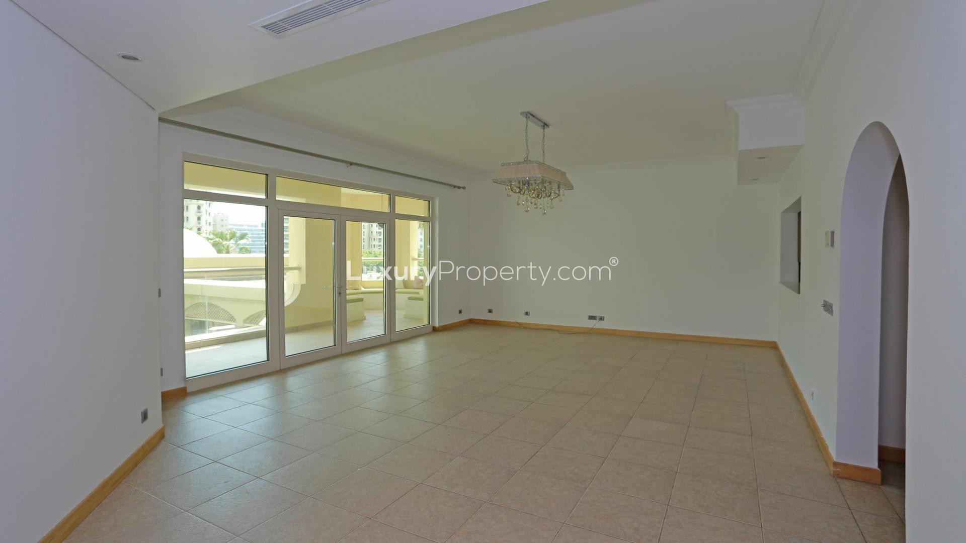 Upgraded living room in Shoreline Apartments, Palm Jumeirah, with balcony view. High ROI opportunity