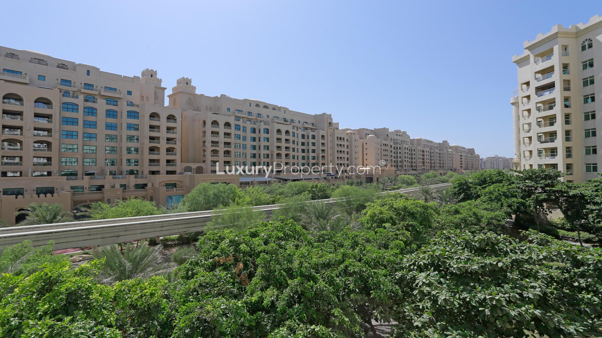 Luxurious empty living room in Shoreline Apartments, Palm Jumeirah, with large windows and tile flooring