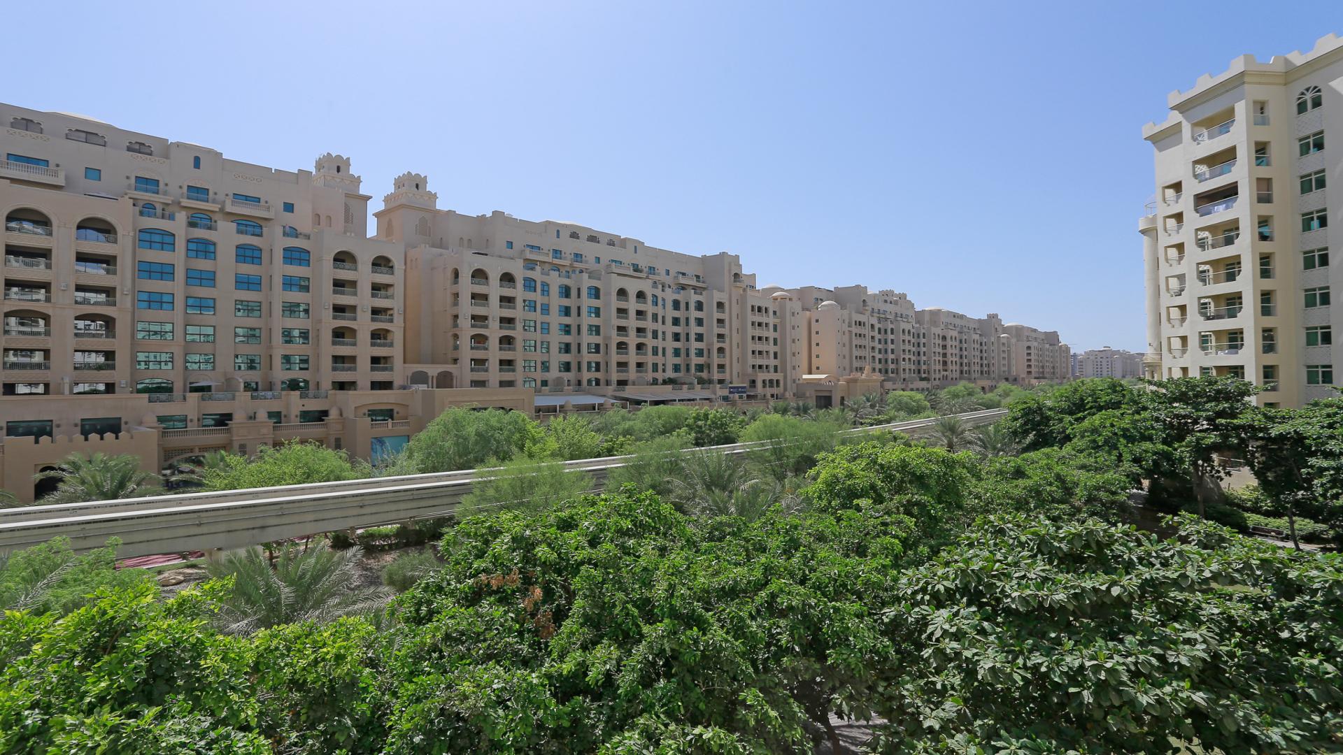 Luxurious empty living room in Shoreline Apartments, Palm Jumeirah, with large windows and tile flooring