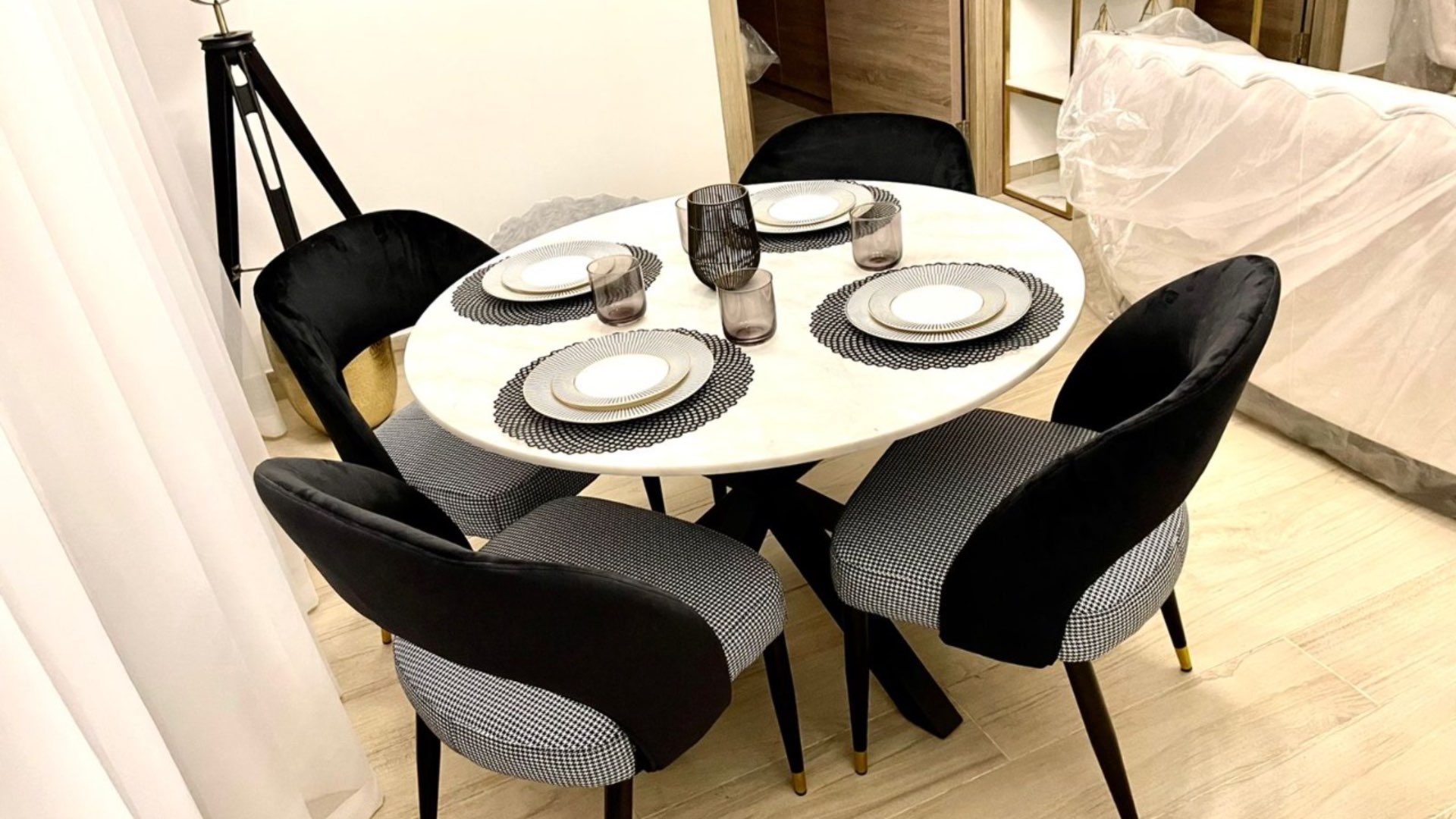 Balcony view of Dubai Marina from Studio One apartment with hanging chair and plant