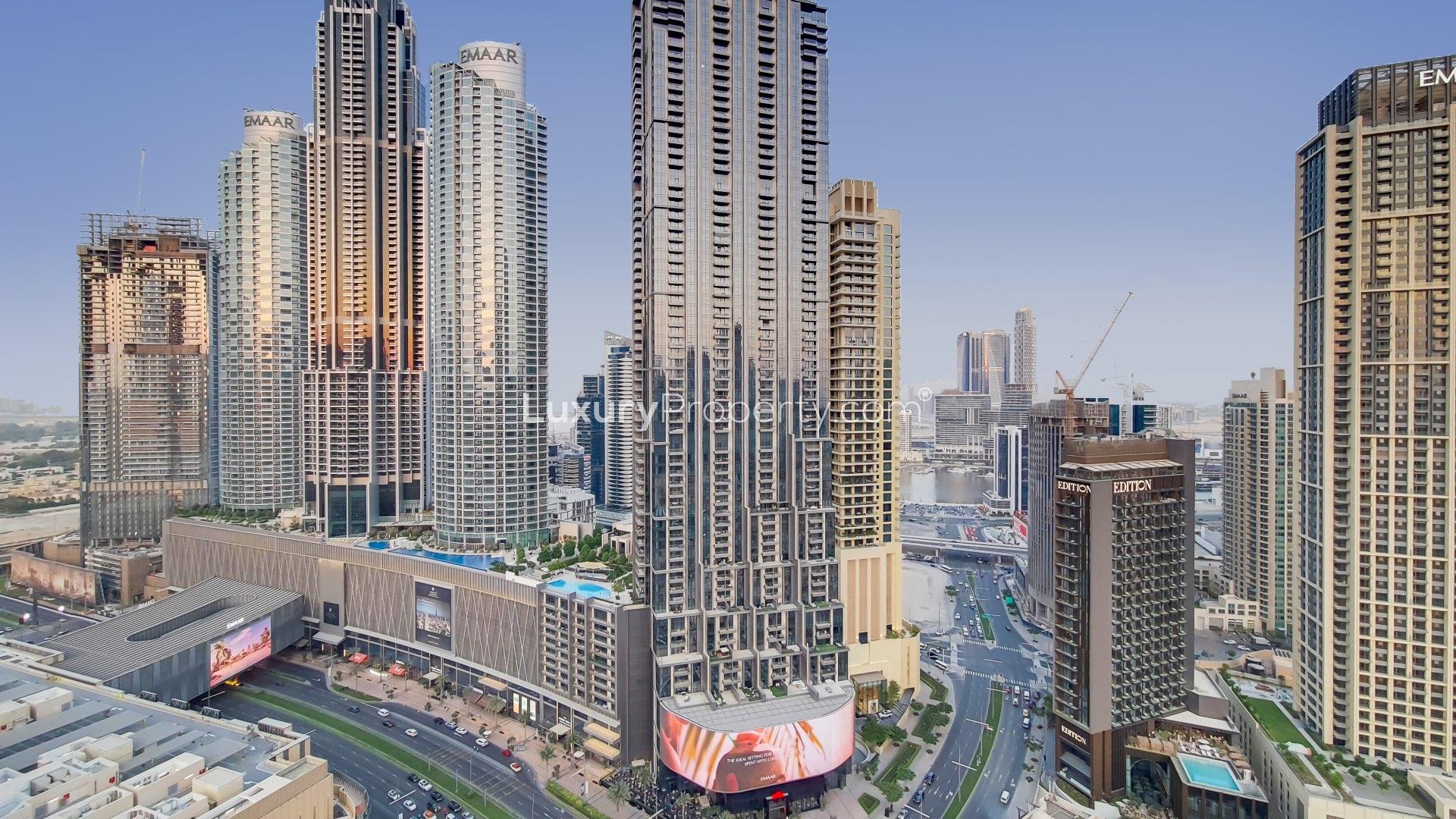 "Luxurious bedroom with Burj Khalifa view in Downtown Dubai apartment at The Address.",Skyline view from Downtown Dubai luxury apartment, featuring Burj Khalifa and surrounding skyscrapers