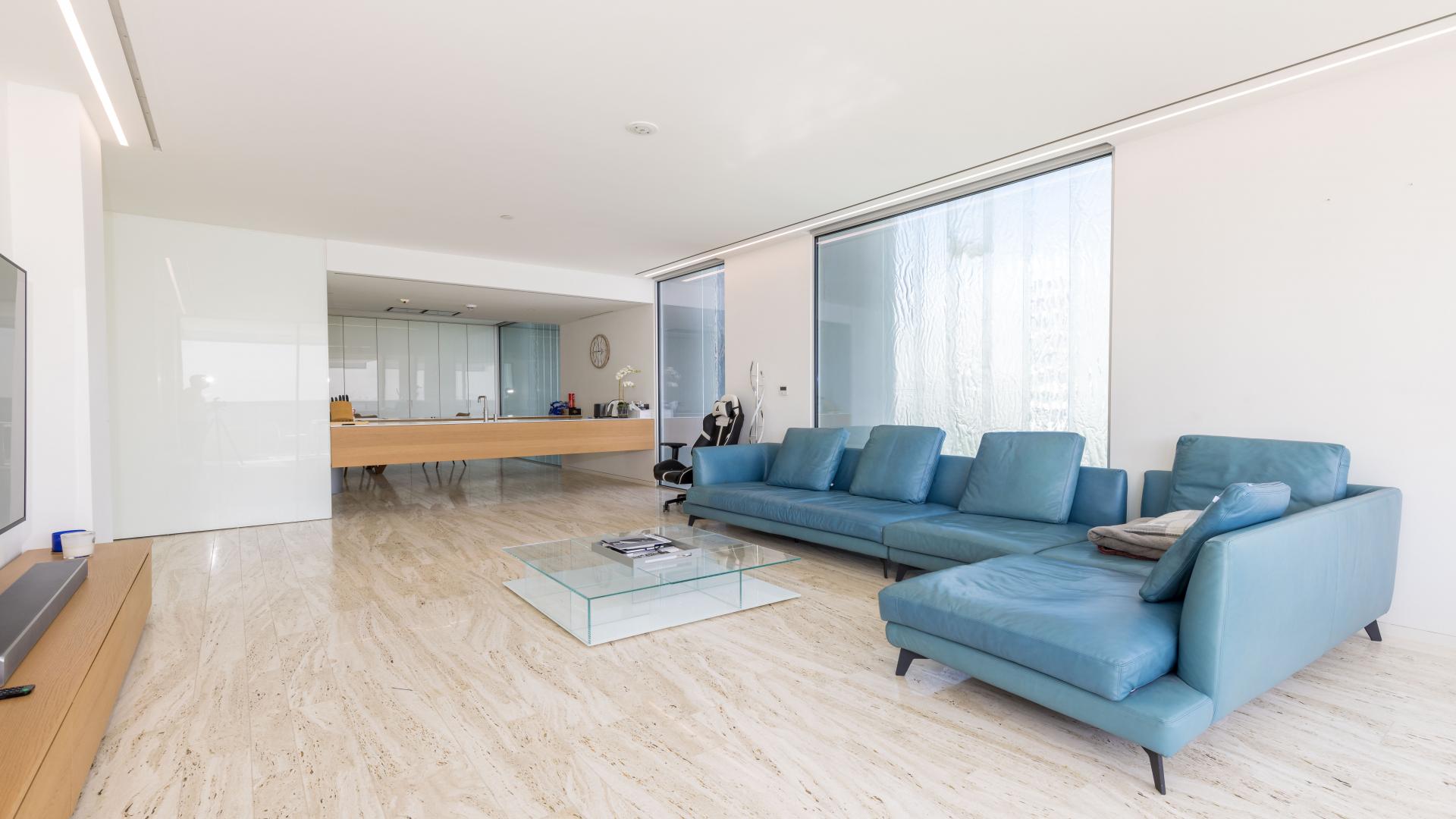 Contemporary furnished living room in Palm Jumeirah apartment with blue sofa and glass table