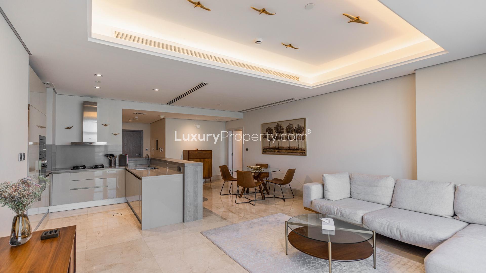 Modern open-plan living and kitchen area in beachfront Palm Jumeirah apartment for sale.