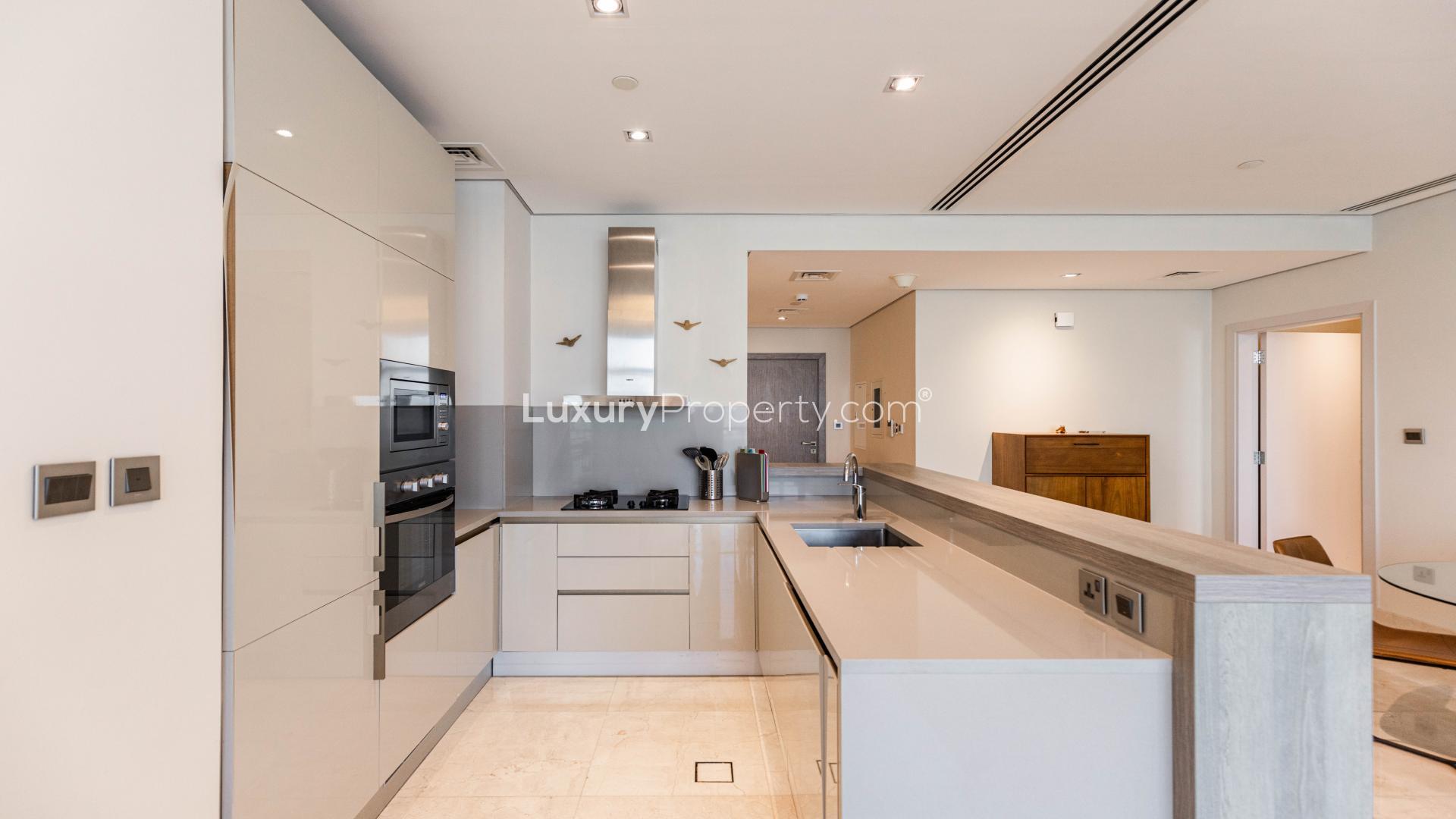 Modern open-plan living and kitchen area in beachfront Palm Jumeirah apartment for sale
