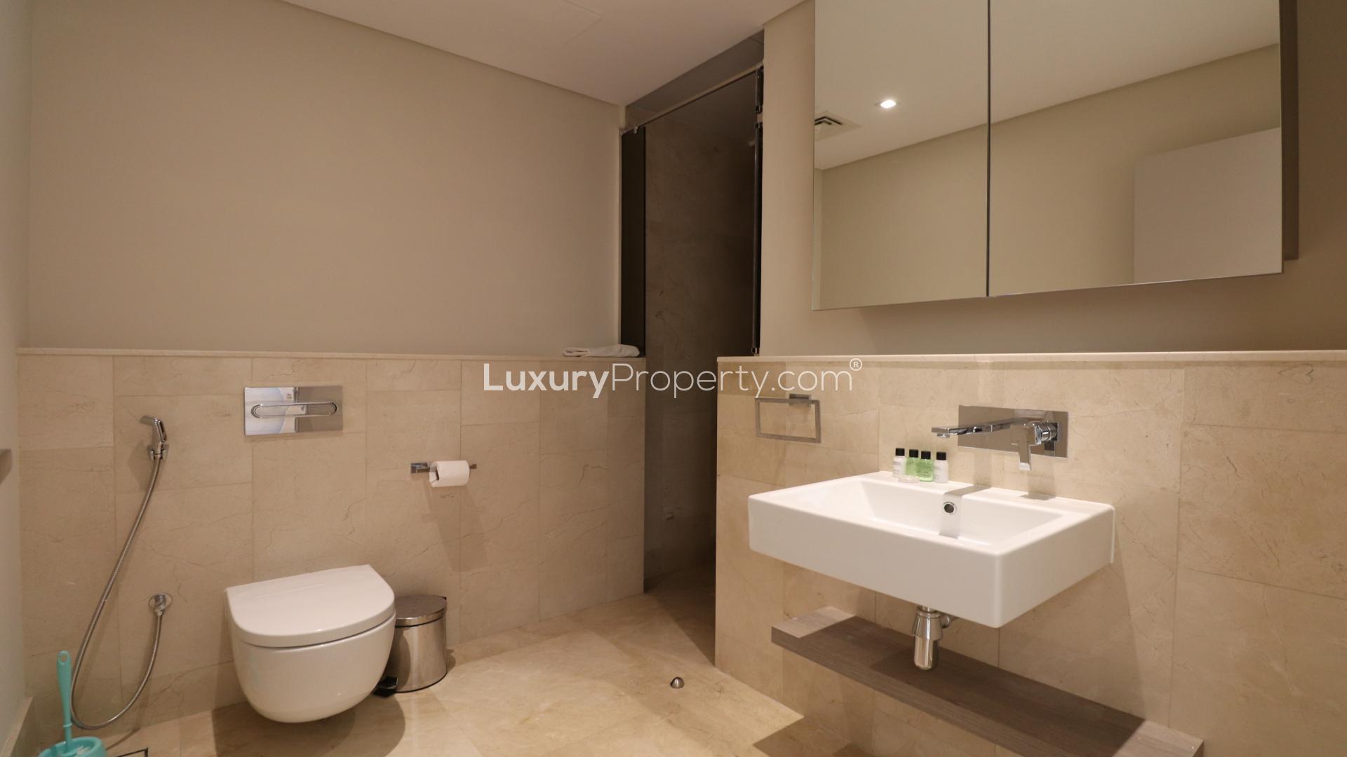 High-floor Palm Jumeirah apartment bedroom with modern decor, large bed, and ample storage