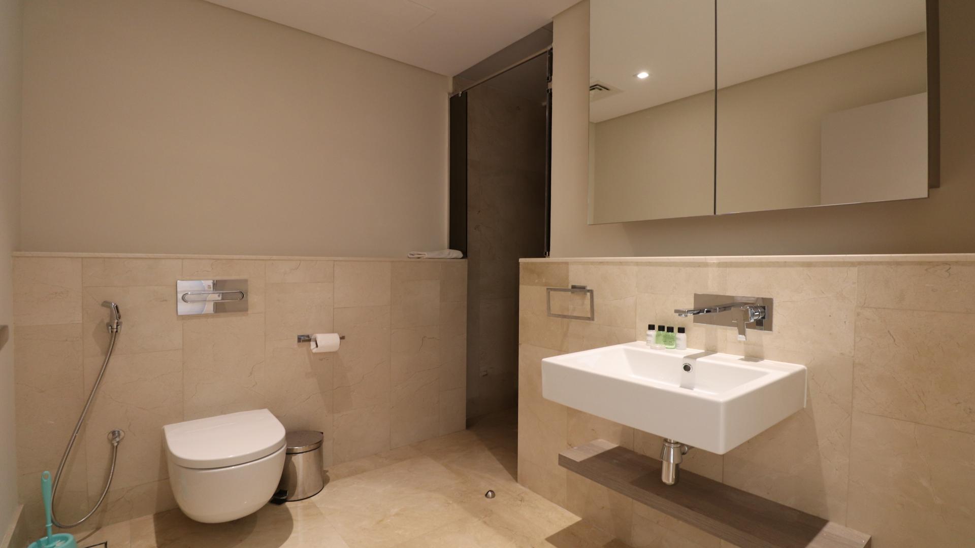 High-floor Palm Jumeirah apartment bedroom with modern decor, large bed, and ample storage