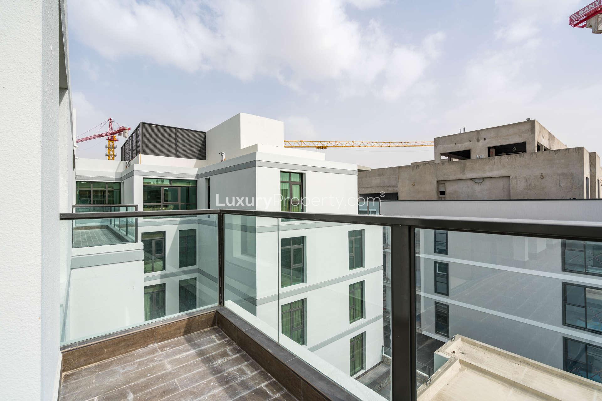 "View from balcony of new two-bedroom apartment in Meydan Avenue, Dubai for sale.",Bright living area with large windows in Meydan Avenue apartment for sale