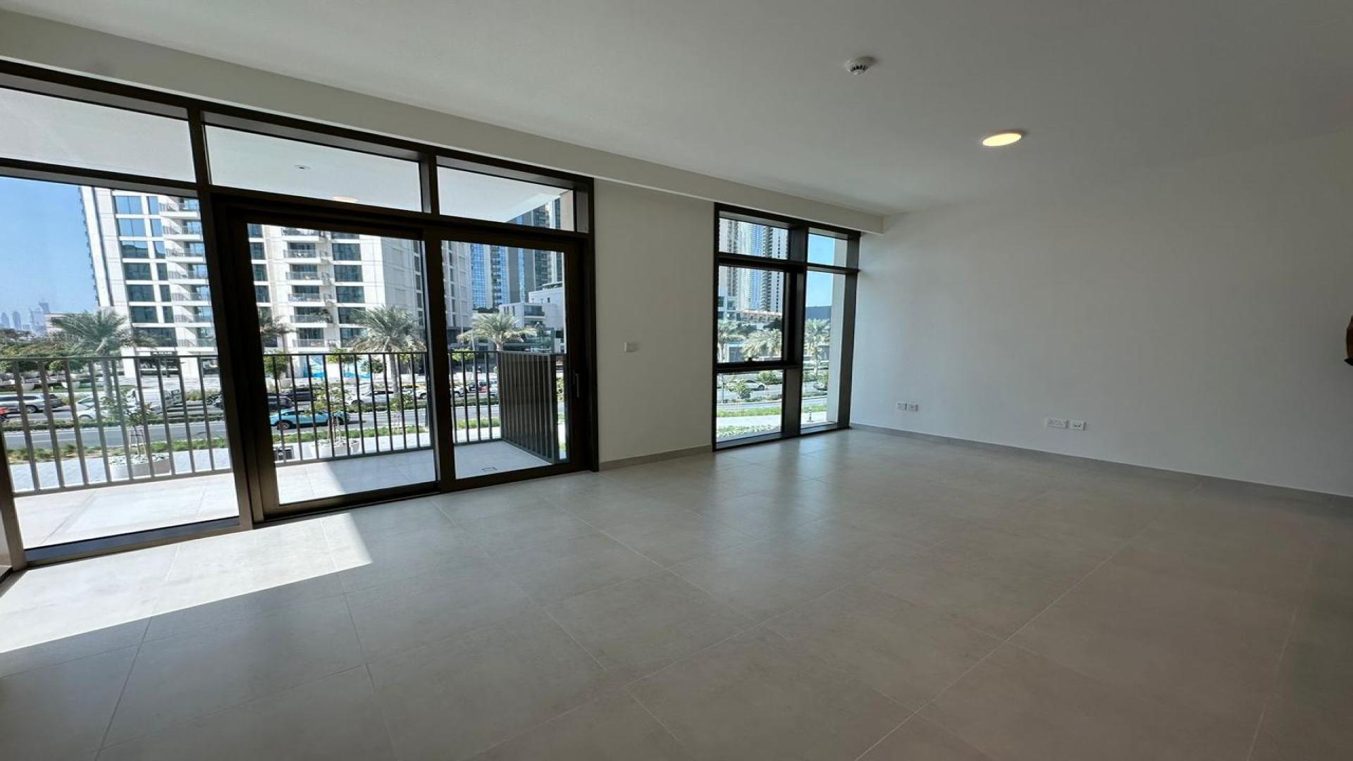 Empty living room in Creek Palace apartment, Dubai Creek Harbour with large window view