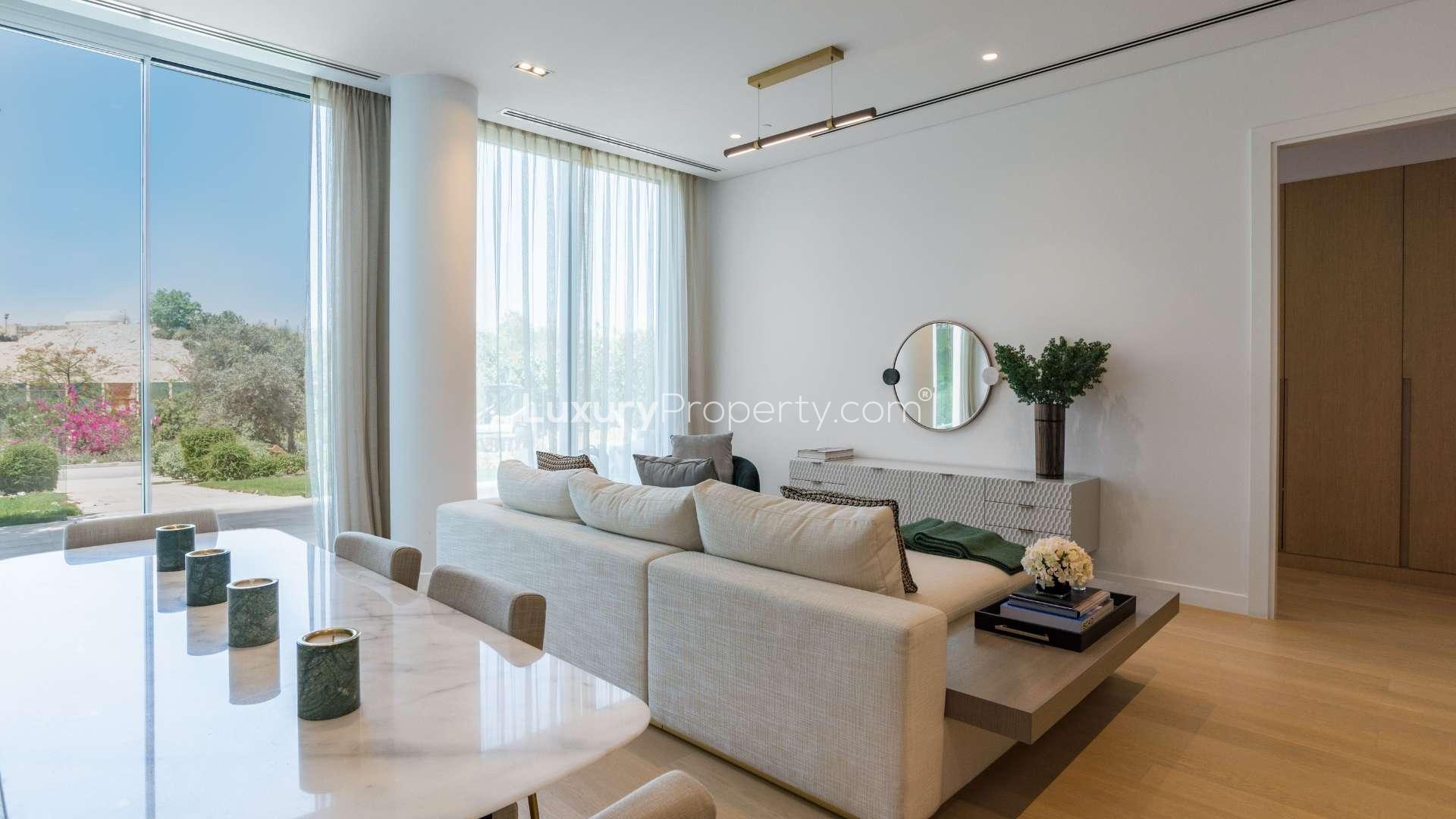 Modern kitchen and living area in Al Barari duplex flat, The Neighbourhood community