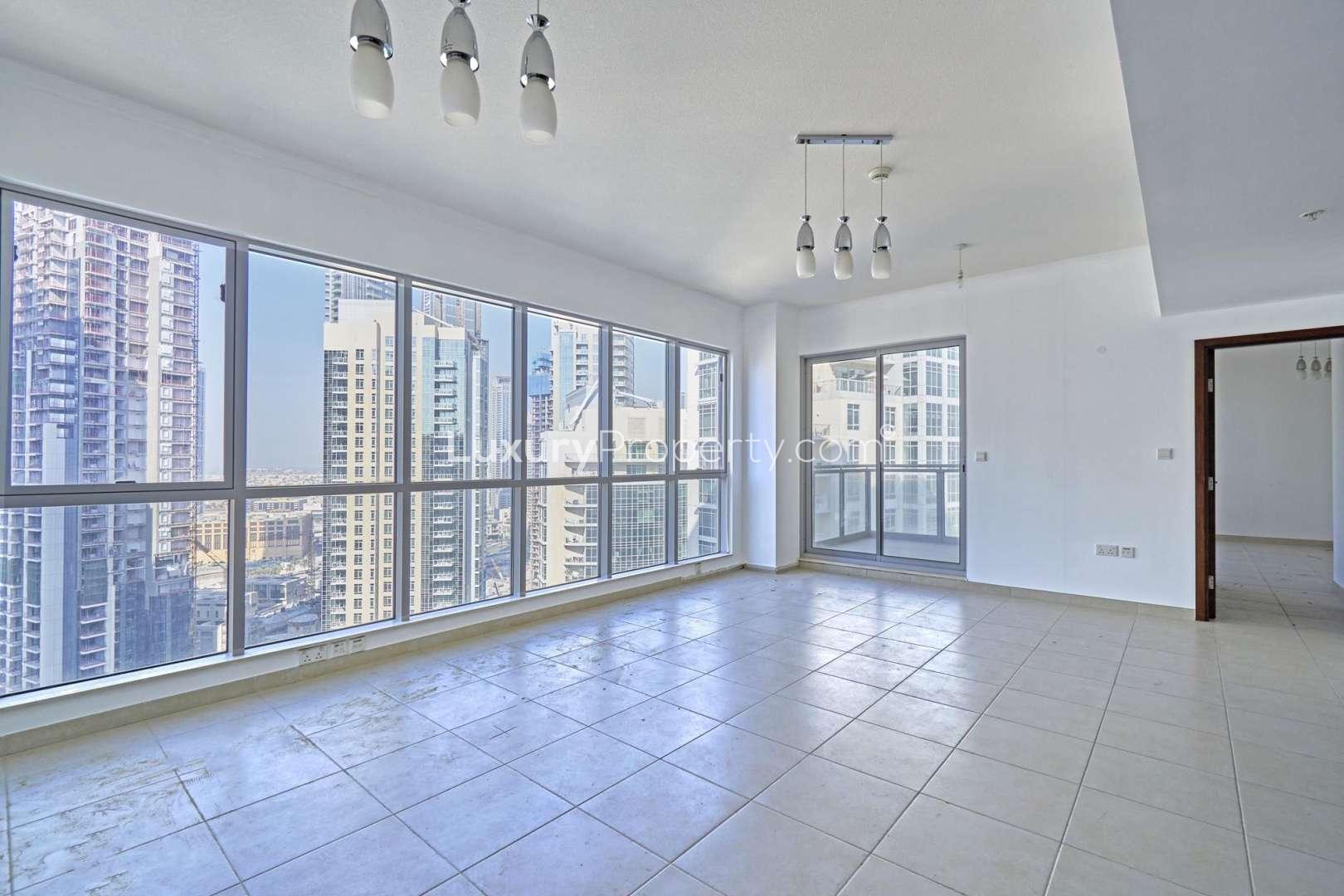 Empty Downtown Dubai apartment with Burj Khalifa view through large window, tiled floors
