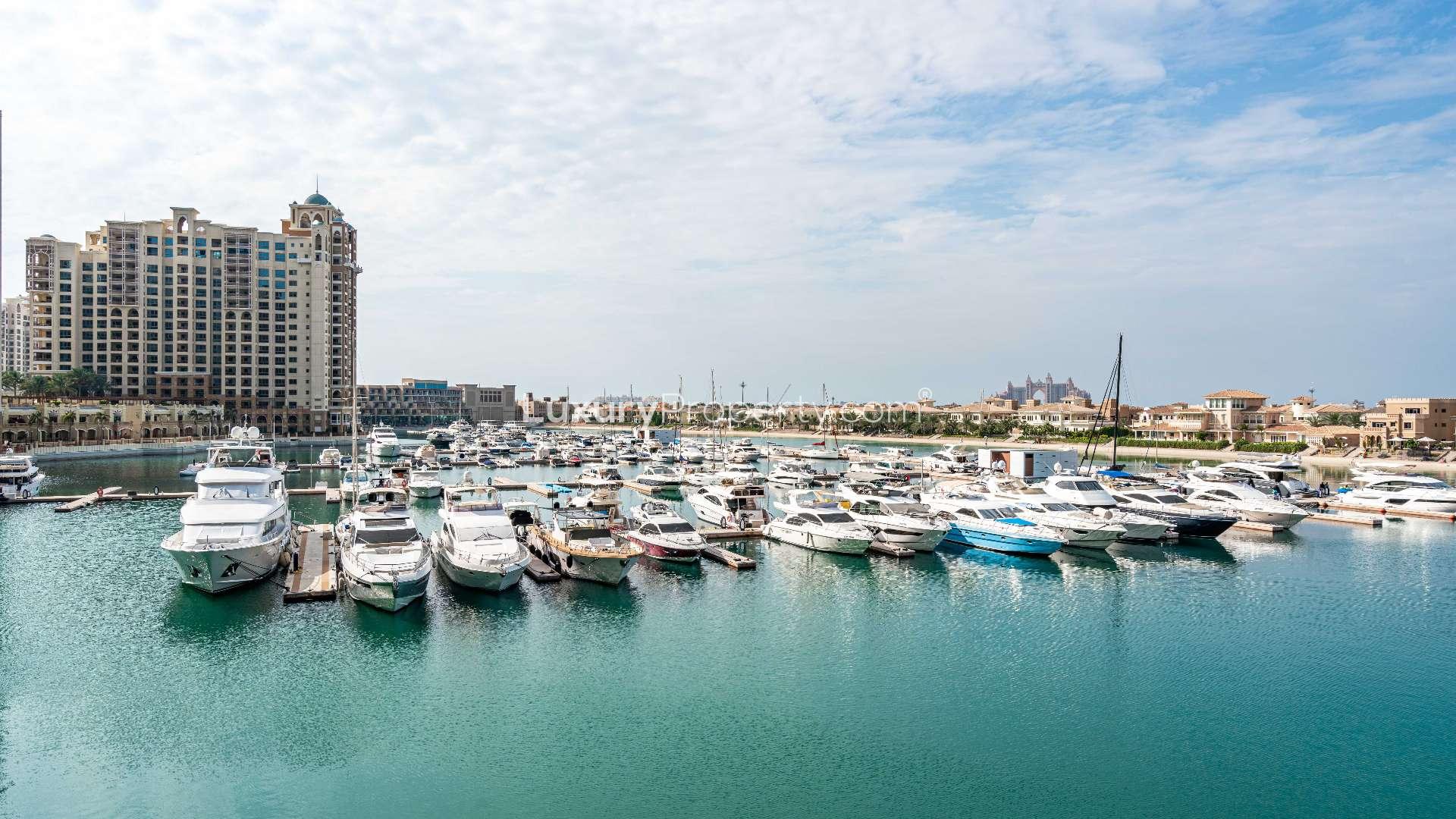 Beachfront view from luxury apartment in Tiara Residences, Palm Jumeirah, with loungers and kayaks