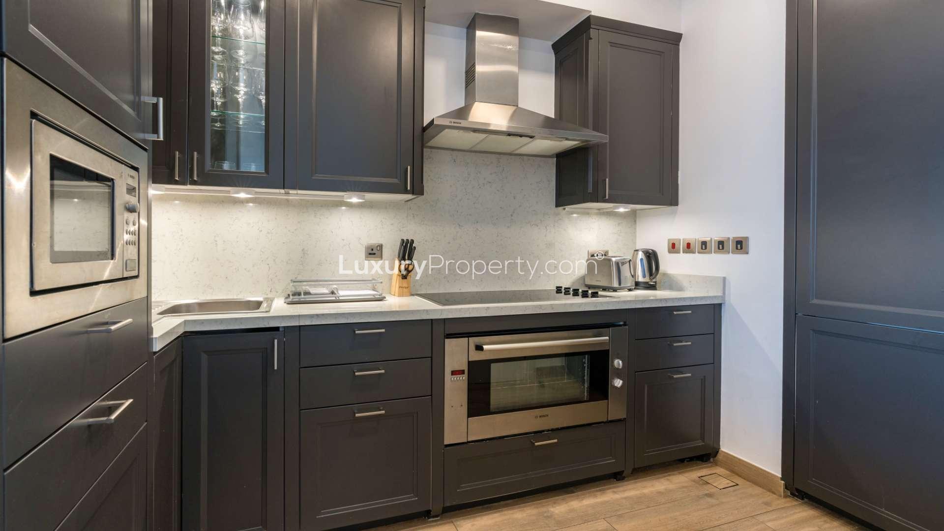 Modern kitchen in Tiara Residences apartment, featuring sleek appliances and elegant cabinetry