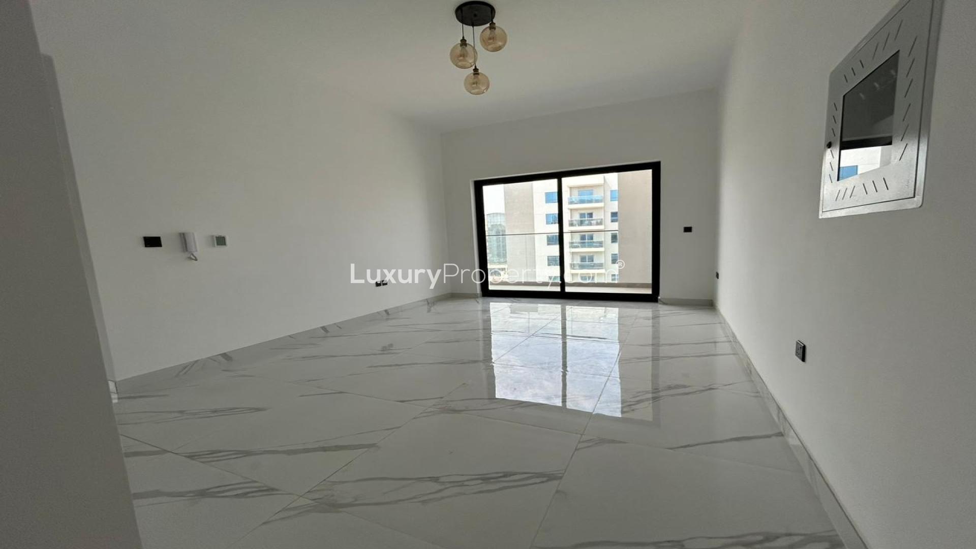 "Balcony view of Gardenia Livings apartment overlooking tennis court and community area in Arjan.",Brand-new 2-bedroom corner unit apartment interior with large window, Arjan, Gardenia Livings