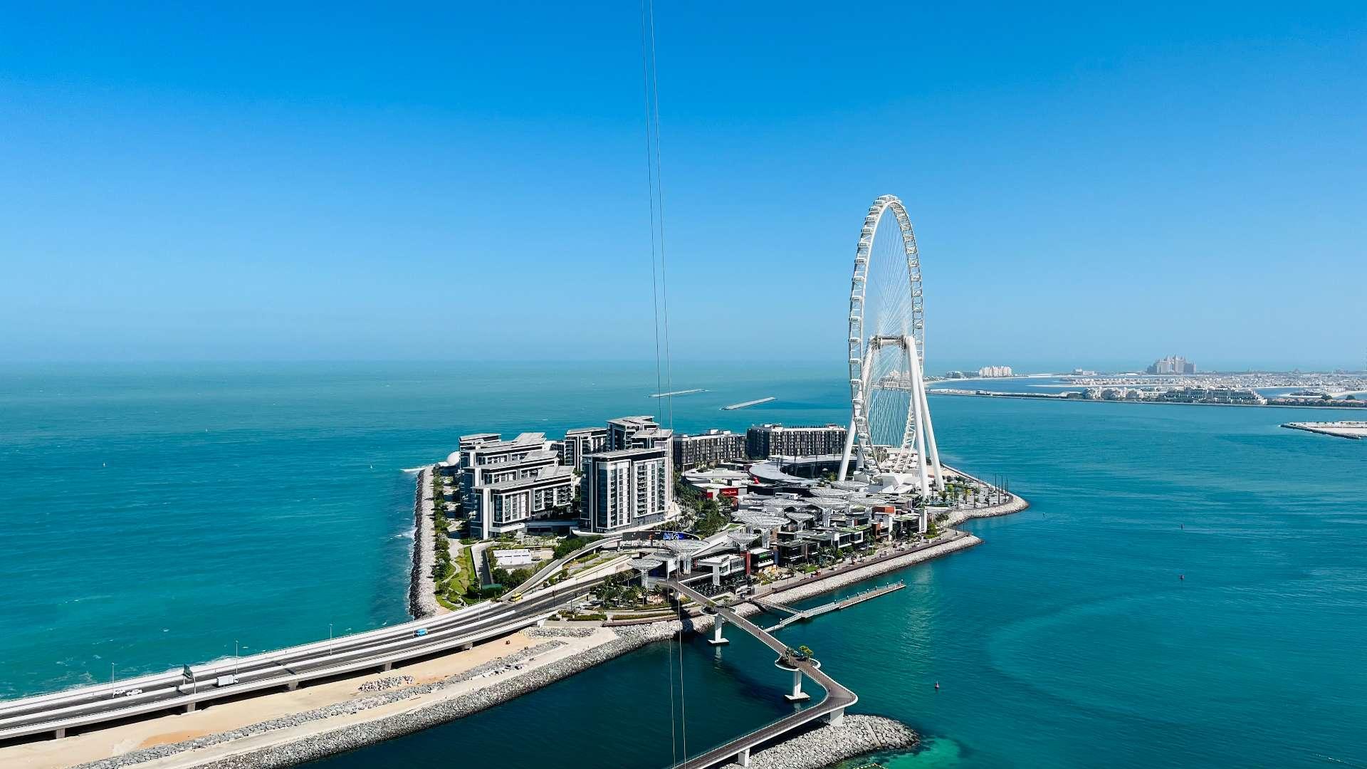 Modern living room in Address JBR apartment with sea view, glass table, and TV
