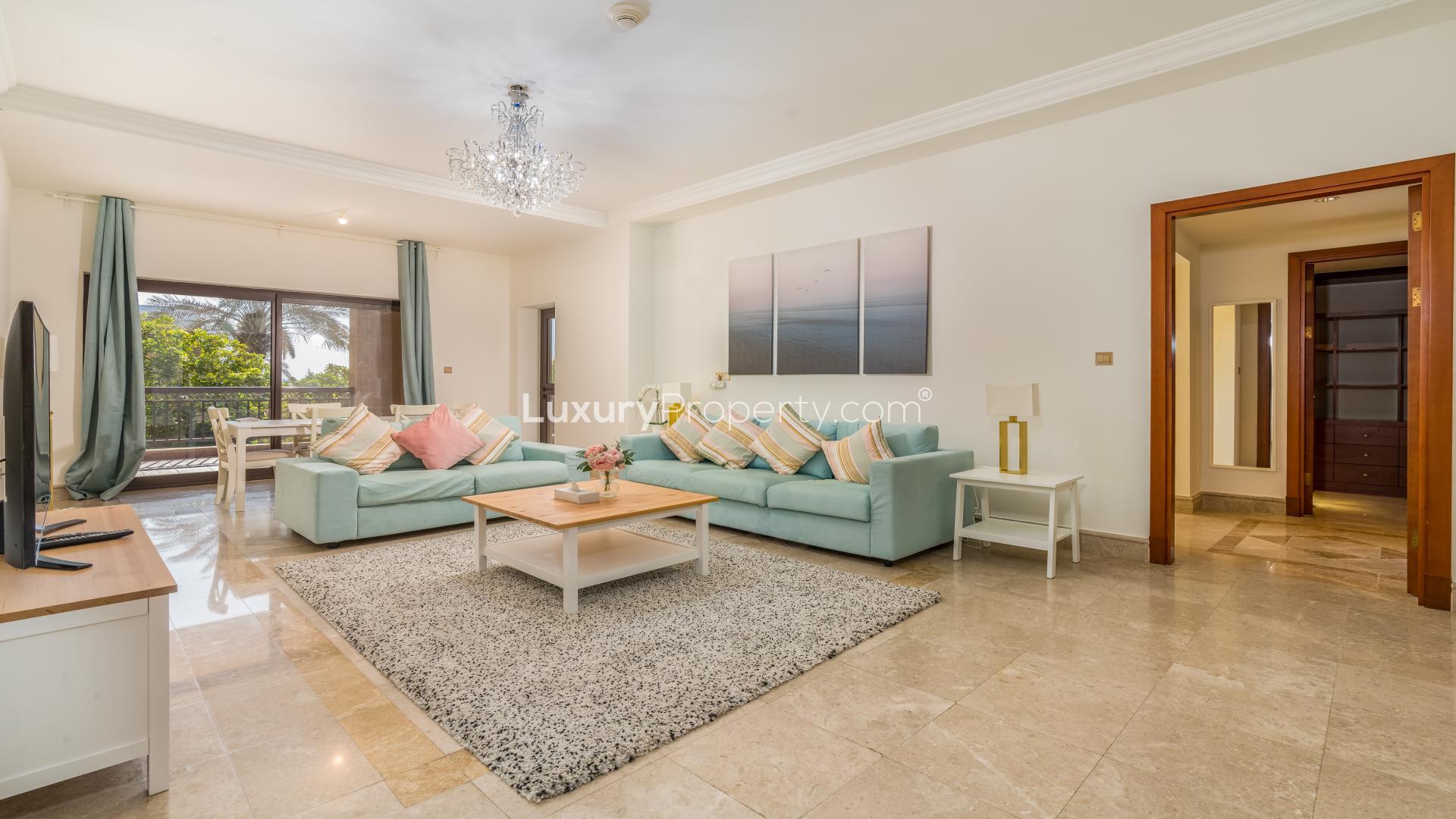 Spacious balcony at The Fairmont Palm Residence North, overlooking pool and lush greenery